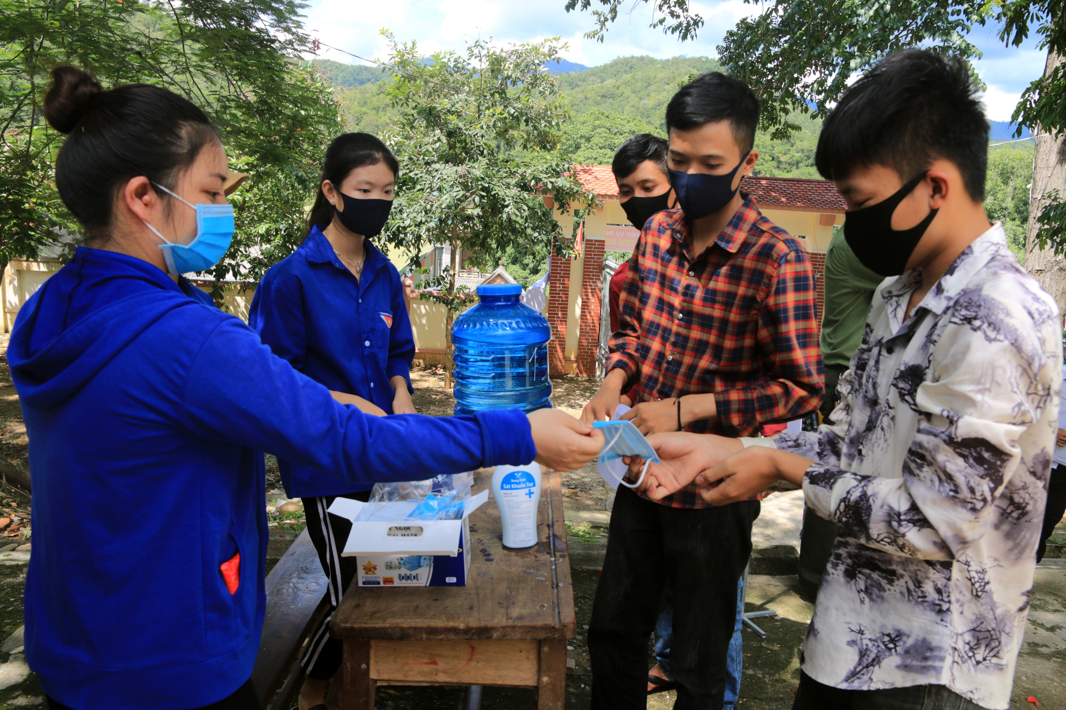 Các tình nguyện viên ở huyện Tương Dương phát khẩu trang cho thí sinh. Ảnh: Đình Tuân