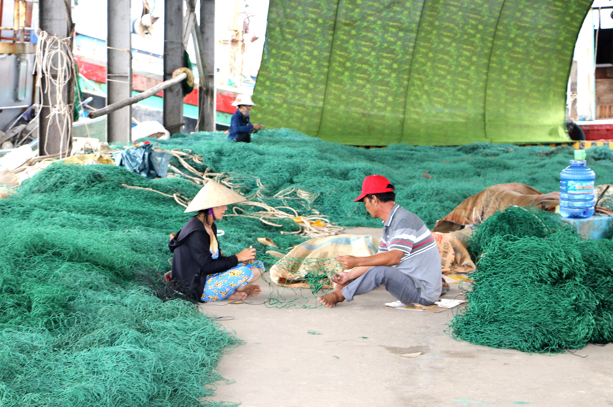 Ngư dân vá lưới  tại cầu cảng chuẩn bị cho đánh bắt dài ngày. Ảnh: Nguyễn Hải