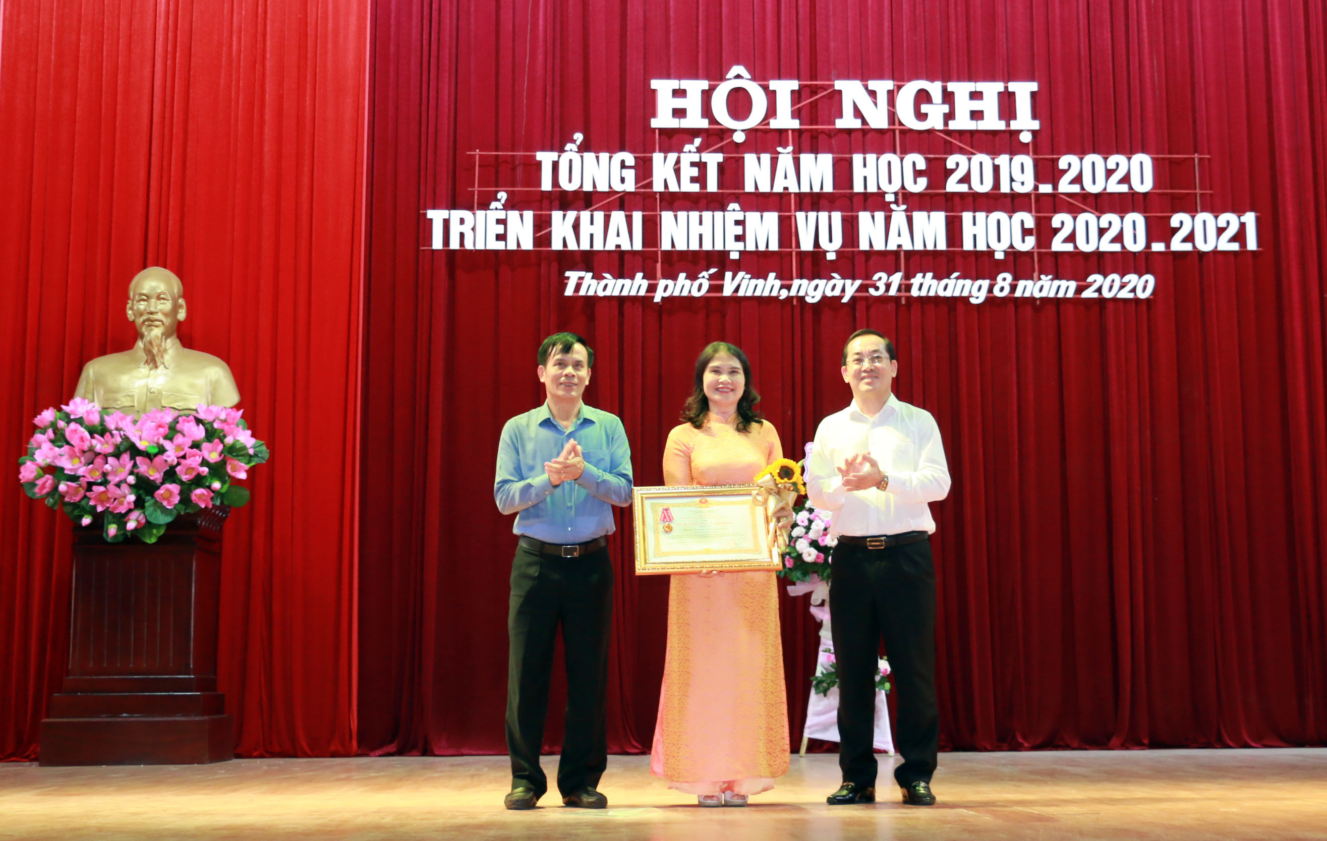 Đồng chí Nguyễn Văn Lư và Trần Ngọc Tú trao tặng Huân chương Lao động hạng 3 cho tập thể Trường THCS Đặng Thai Mai. Ảnh: Mỹ Hà