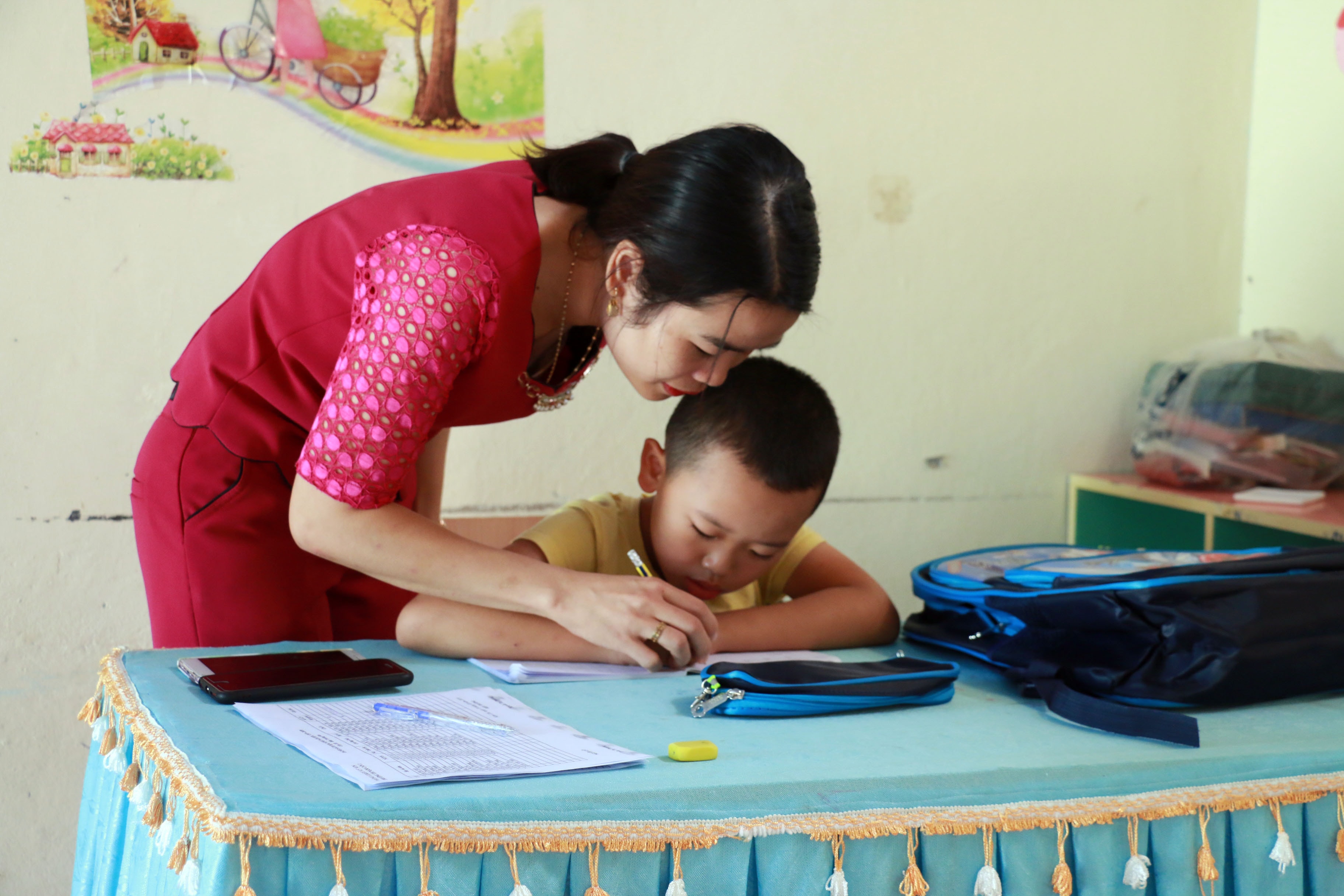 Năm học này, cô giáo Bùi Thị Thúy đem con trai Nguyễn Tiến Minh từ Diễn Châu lên học lớp 1 tại trường. Dù điều này sẽ khó khăn cho con trẻ, đặc biệt là trong việc hòa nhập nhưng điều đó sẽ giúp chị có cơ hội được chăm sóc con thường xuyên hơn. Chồng của chị cũng là bộ đội biên phòng hiện đang công tác tại Đồn biên phòng Quốc tế Cửa khẩu Nậm Cắn. Ảnh: Mỹ Hà