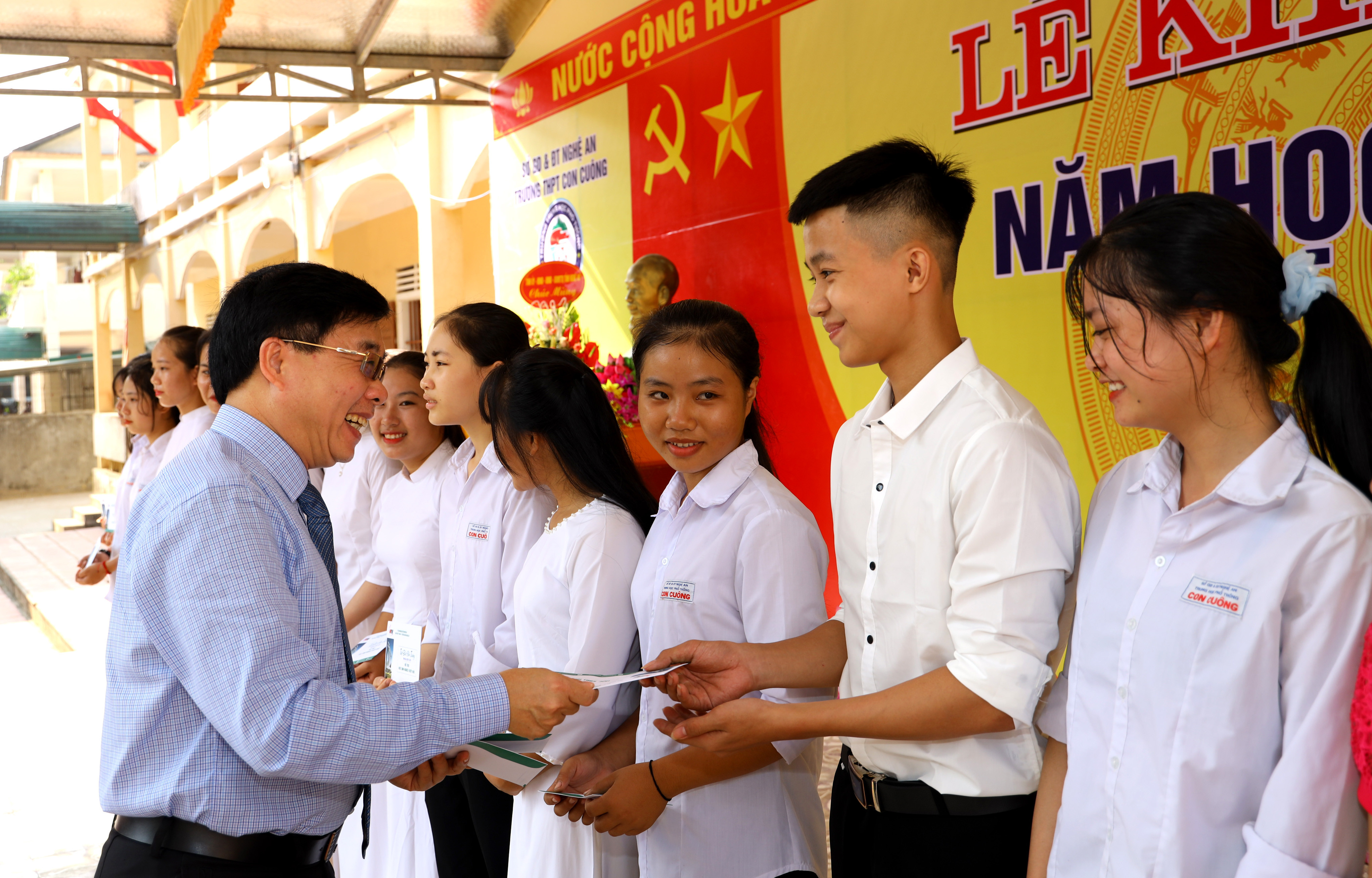 Đồng chí Nguyễn Văn Thông tặng quà các học sinh có thành tích học tập đạt kết quả cao. Ảnh Nguyên Sơn