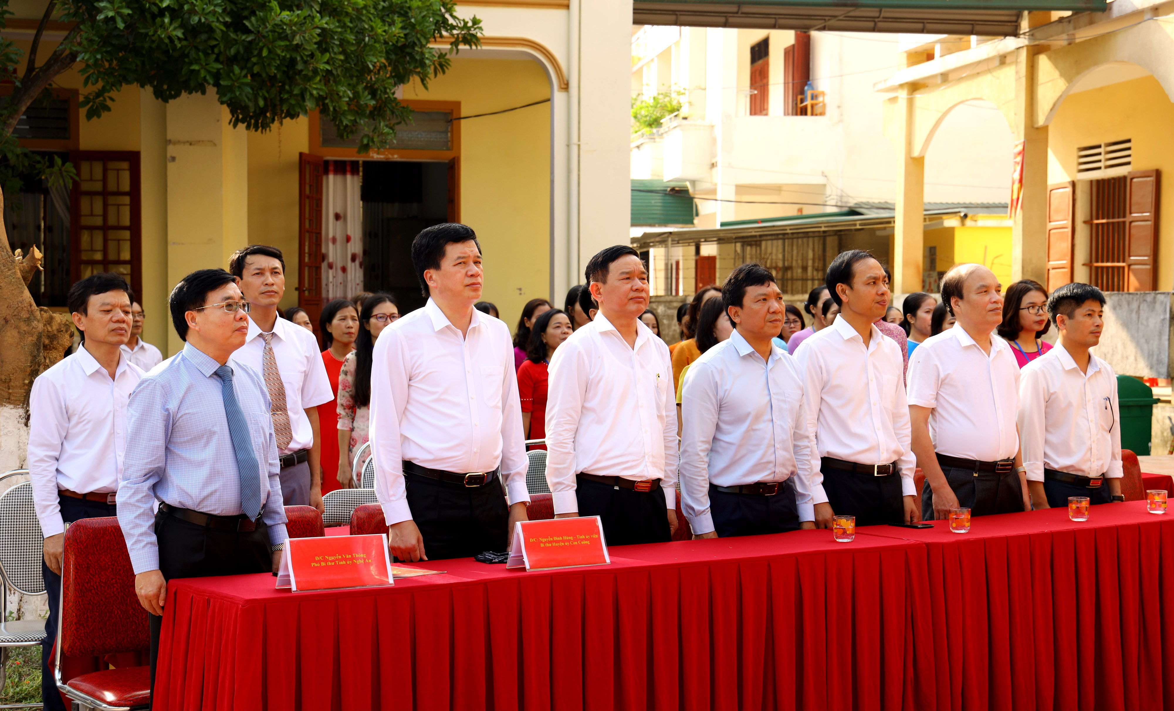 Các đại biểu cùng thầy cô giáo và học sinh Trường THPT Con Cuông thực hiện nghi thức chào cờ trước khi bước vào năm học mới. Ảnh Nguyên Sơn