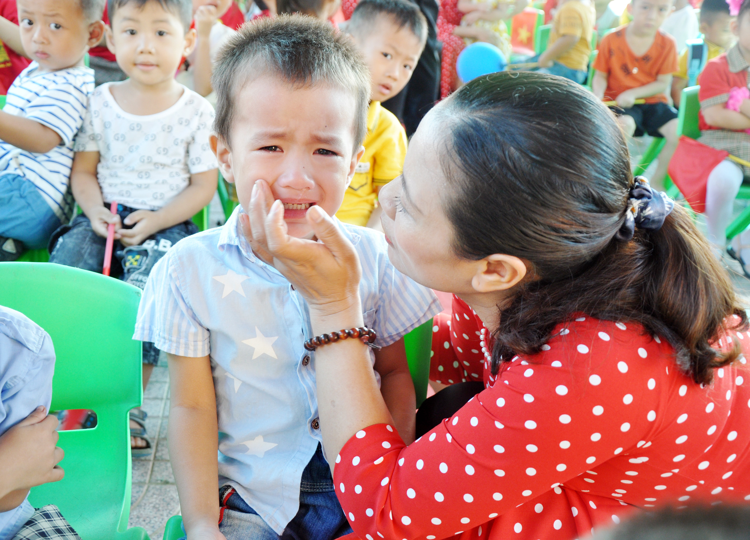 Cô giáo Trường Mầm non Hưng Châu, xã Châu Nhân (Hưng Nguyên) dỗ dành bé trong ngày đầu đến trường. Ảnh: Công Kiên