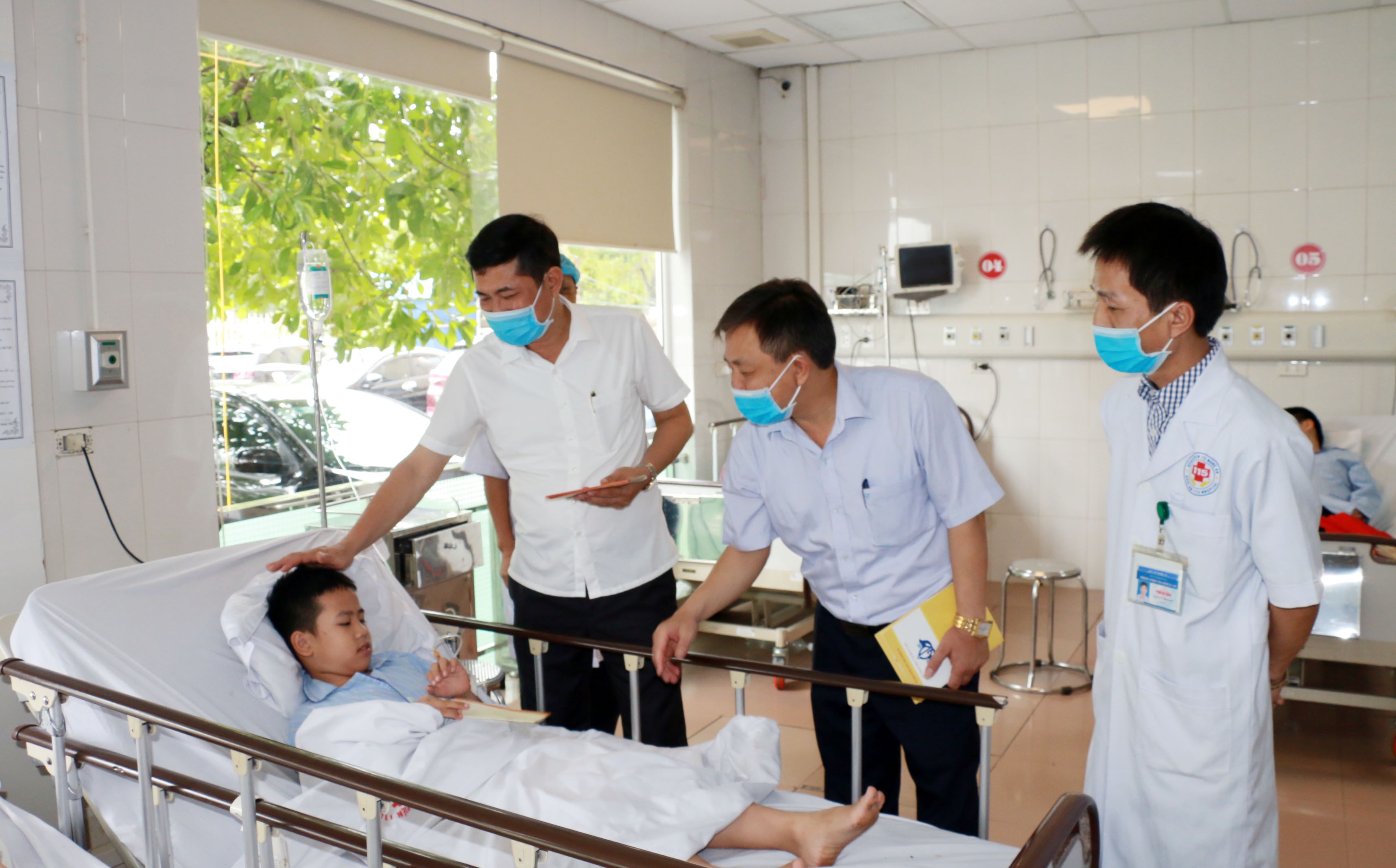 Giám đốc Sở Giáo dục và Đào tạo Thái Văn Thành động viên cho những học sinh đang điều trị tại khoa Hồi sức cấp cứu. Ảnh: Mỹ Hà.