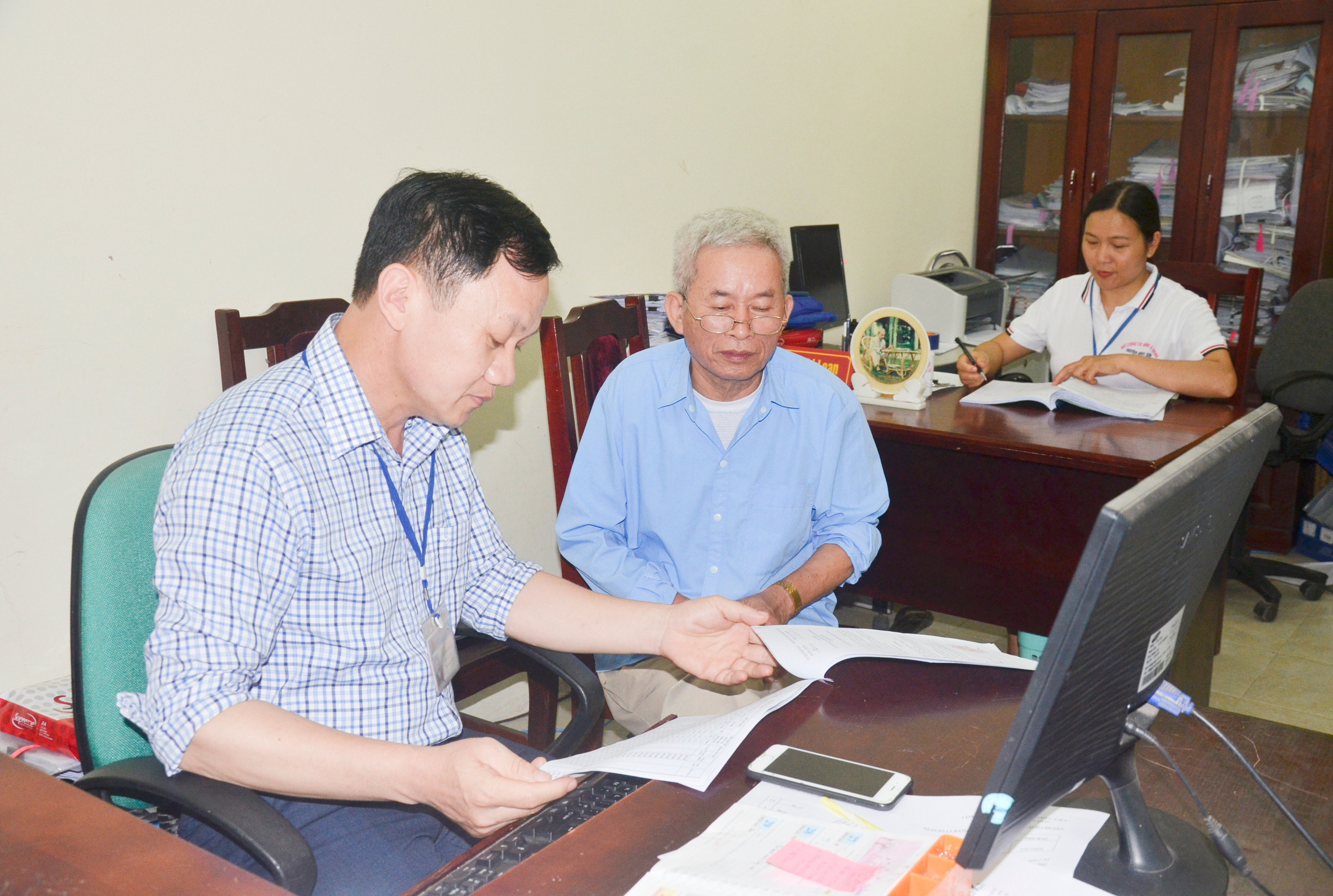 Cán bộ Phòng Nội vụ huyện Anh Sơn hướng dẫn thủ tục hành chính cho người dân. Ảnh: Thanh Lê