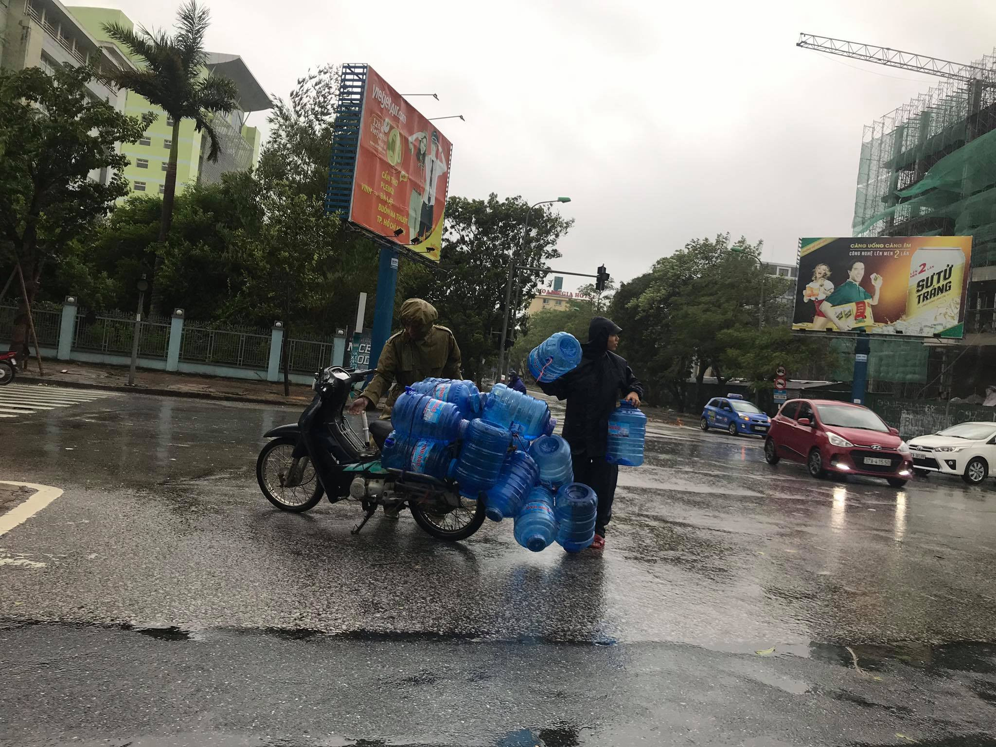 Một chiến sĩ CSGT Thành phố Vinh giúp người dân nhặt chai nhựa bị rơi vào chiều 18/9 trên Đại lộ Lênin. Ảnh: H.T