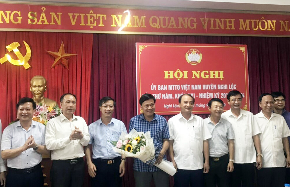 Các đại biểu tặng hoa chúc mừng tân Chủ tịch Ủy ban MTTQ huyện Nghi Lộc Hồ Nam nhận nhiệm vụ mới. Ảnh: Trung Dũng 