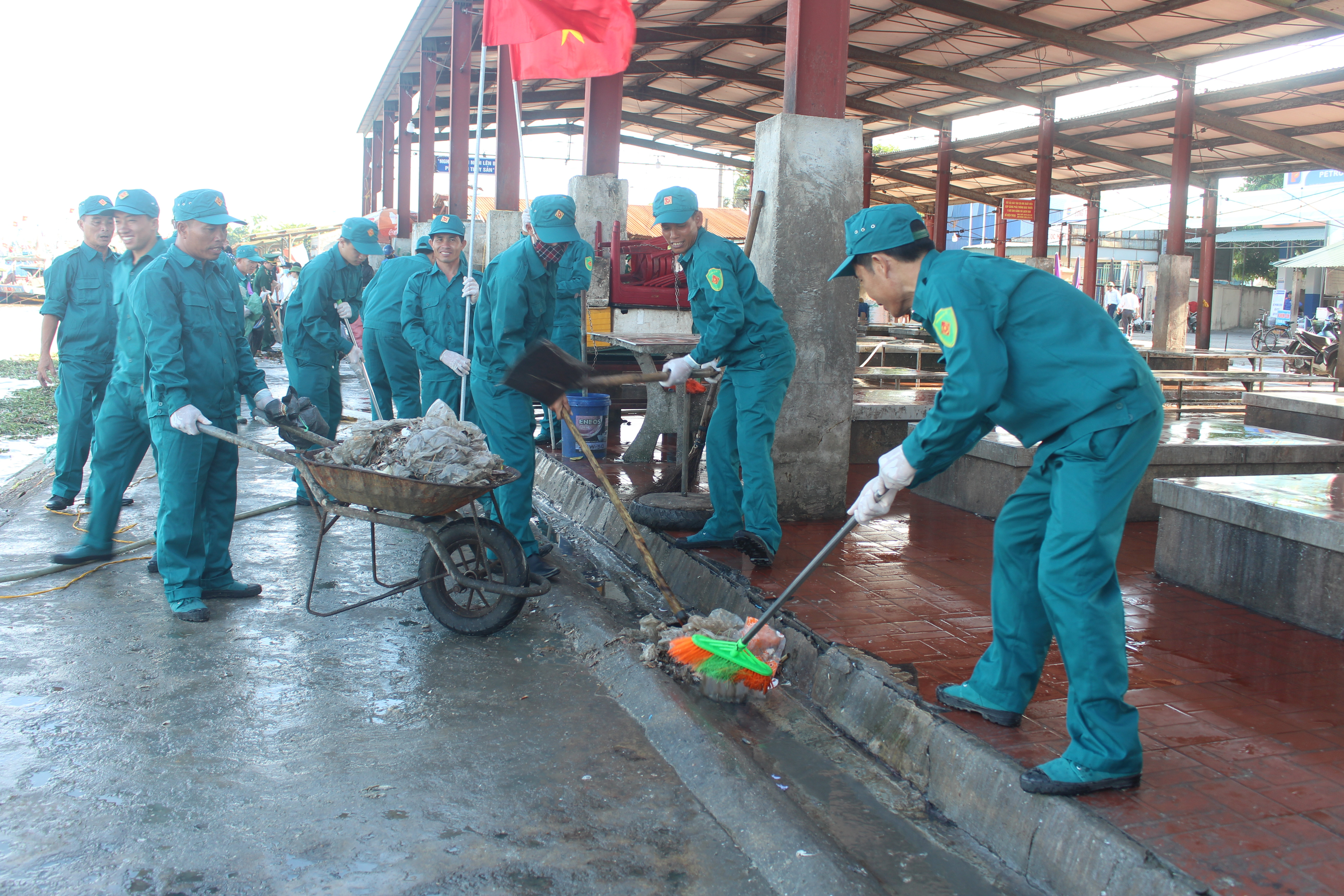 Lực lượng Dân quân tự vệ huyện Diễn Châu giúp người dân dọn dẹp môi trường ven biển. Ảnh: MH