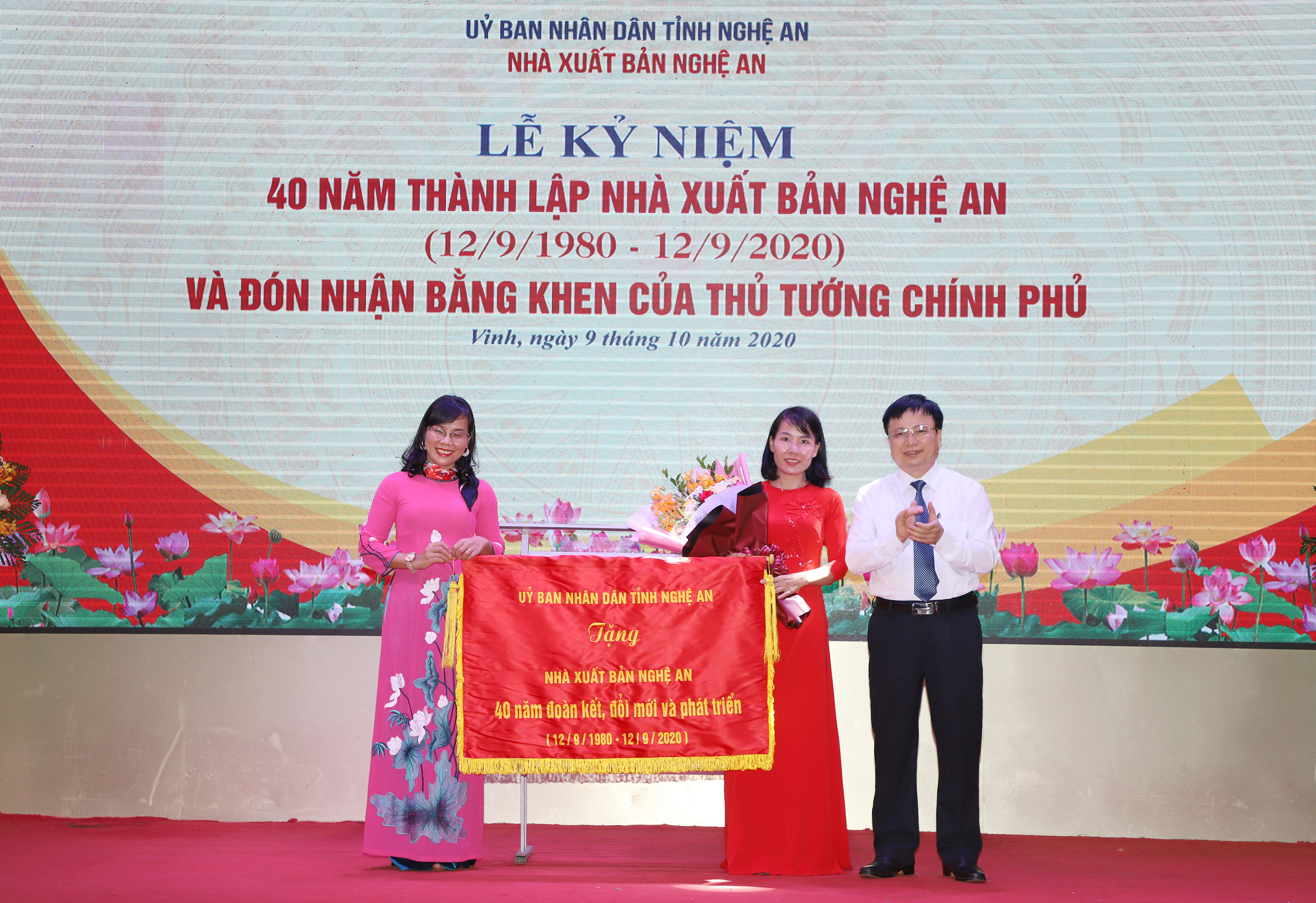 Đồng chí Bùi Đình Long - Phó Chủ tịch UBND tỉnh trao bức trướng của UBND tỉnh cho Nhà xuất bản Nghệ An. Ảnh: Phạm Bằng