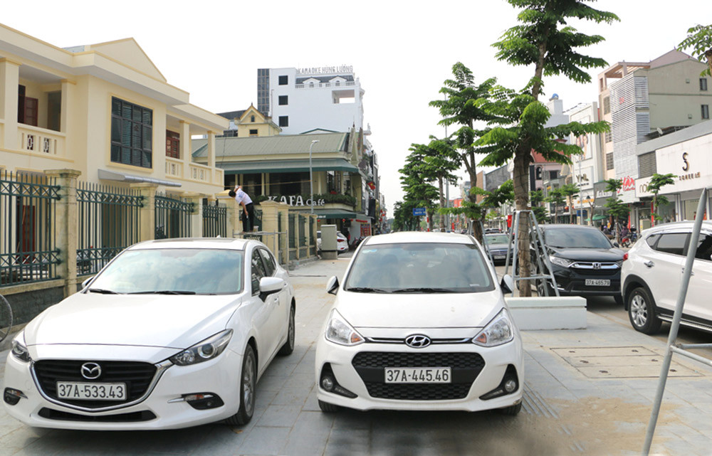 Vỉa hè đường Nguyễn Văn Cừ được phép  dừng đậu xe góp phần giảm ùn tắc. Ảnh: Nguyễn Hải