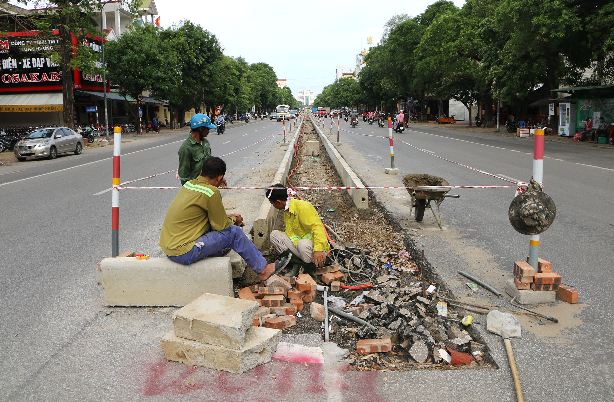 Công nhân đang thi công hạng mục xén bouleva trông hoa cây cảnh 2 bên đường Trần Phú và làm dải phân cách mới trên đường Trần Phú để giảm ùn tắc. Ảnh: Trần Phú