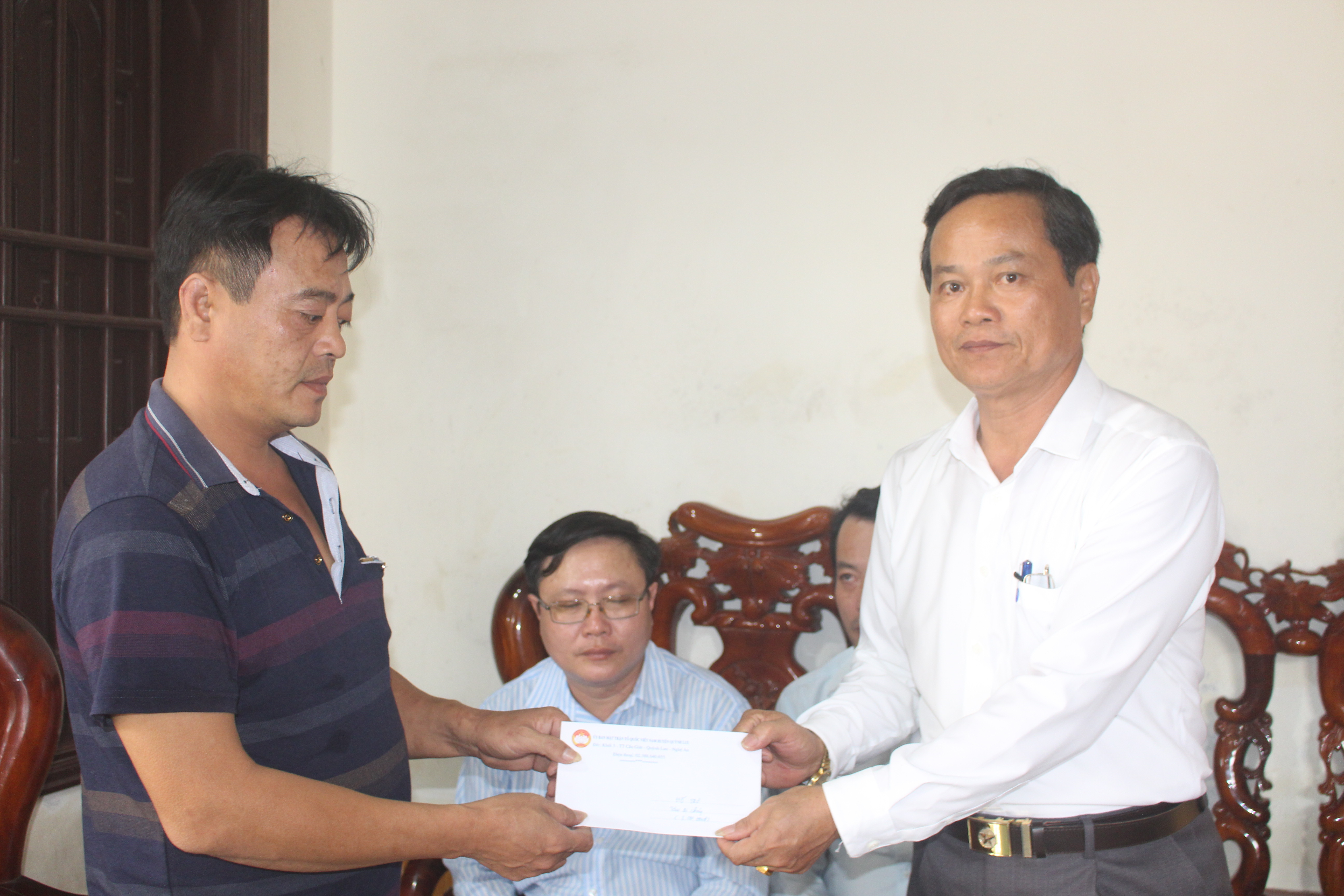 UBMTTQ huyện Quỳnh Lưu trao tiền hỗ trợ cho các thuyền viên có tàu cá bị cháy. Ảnh: Việt Hùng