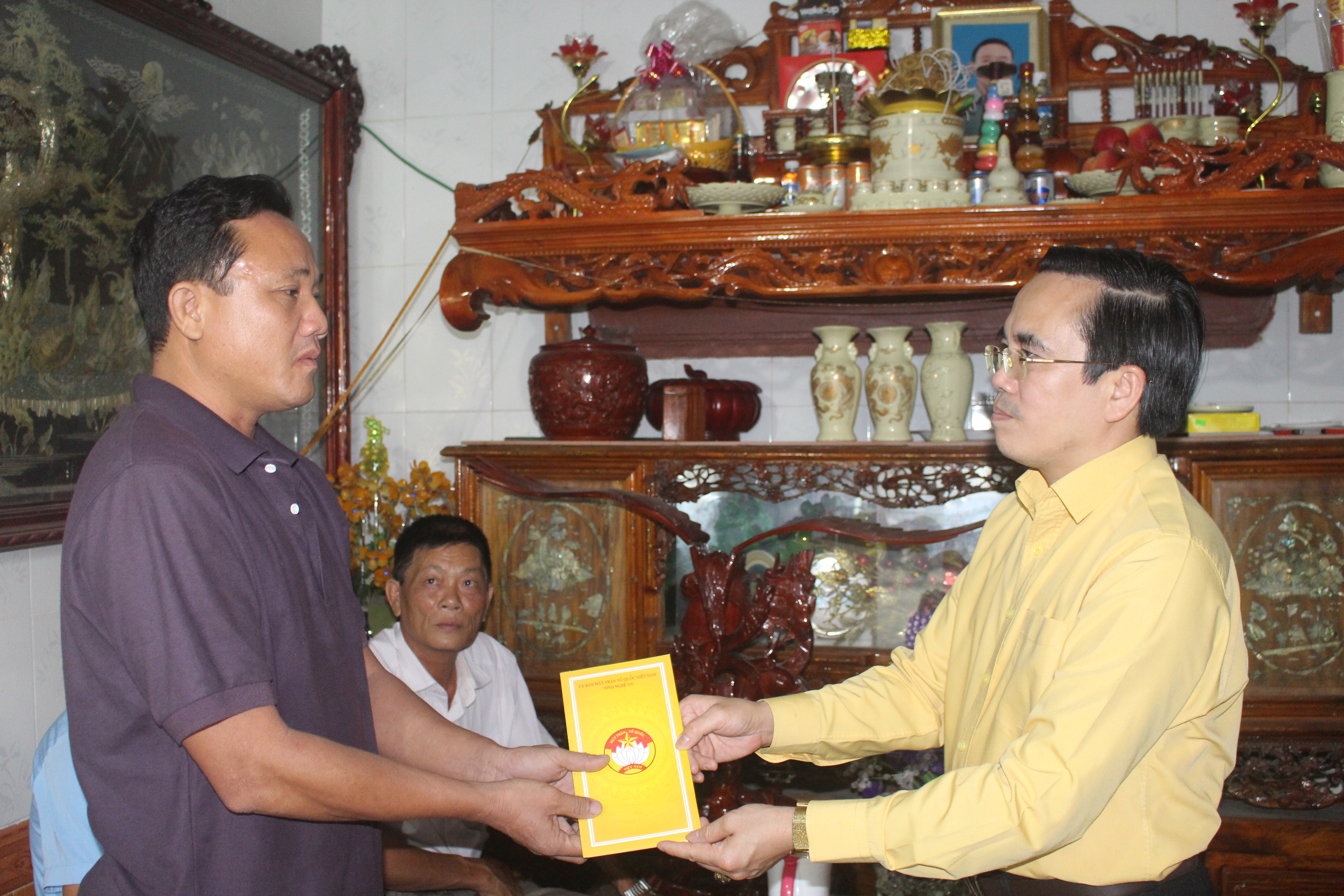 Phó Chủ tịch thường trực UBMTTQ tỉnh Lê Văn Ngọc trao tiền hỗ trợ cho các thuyền viên có tàu cá bị cháy. Ảnh: Việt Hùng