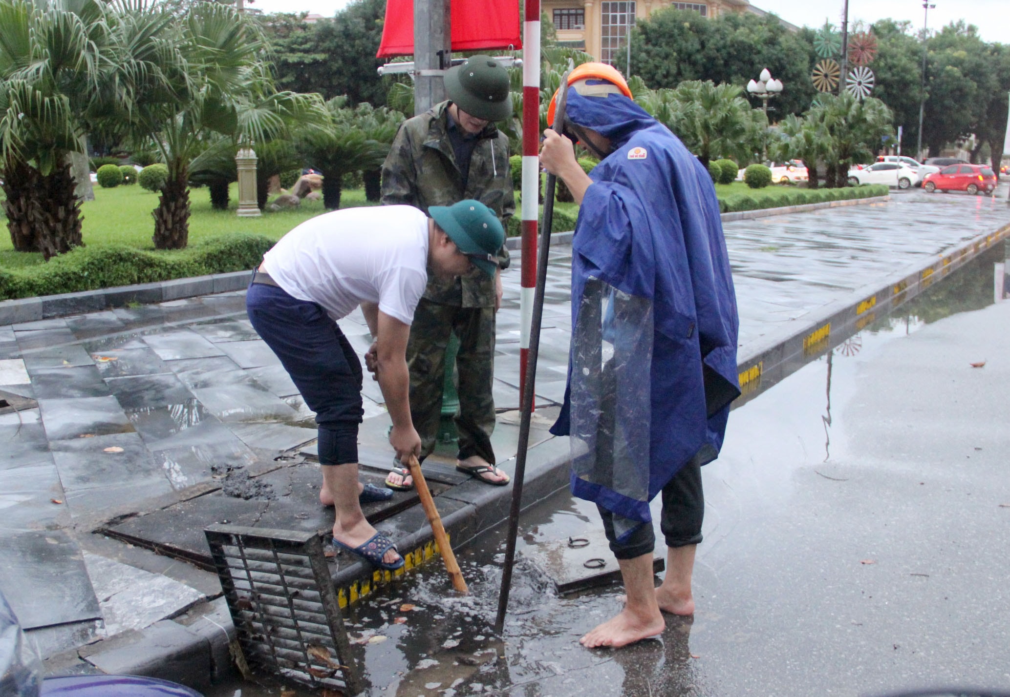 Lực lượng chức năng TP.Vinh khơi thông cống trên tuyến đường Trường Thi sáng 14/10. Ảnh: Quang An