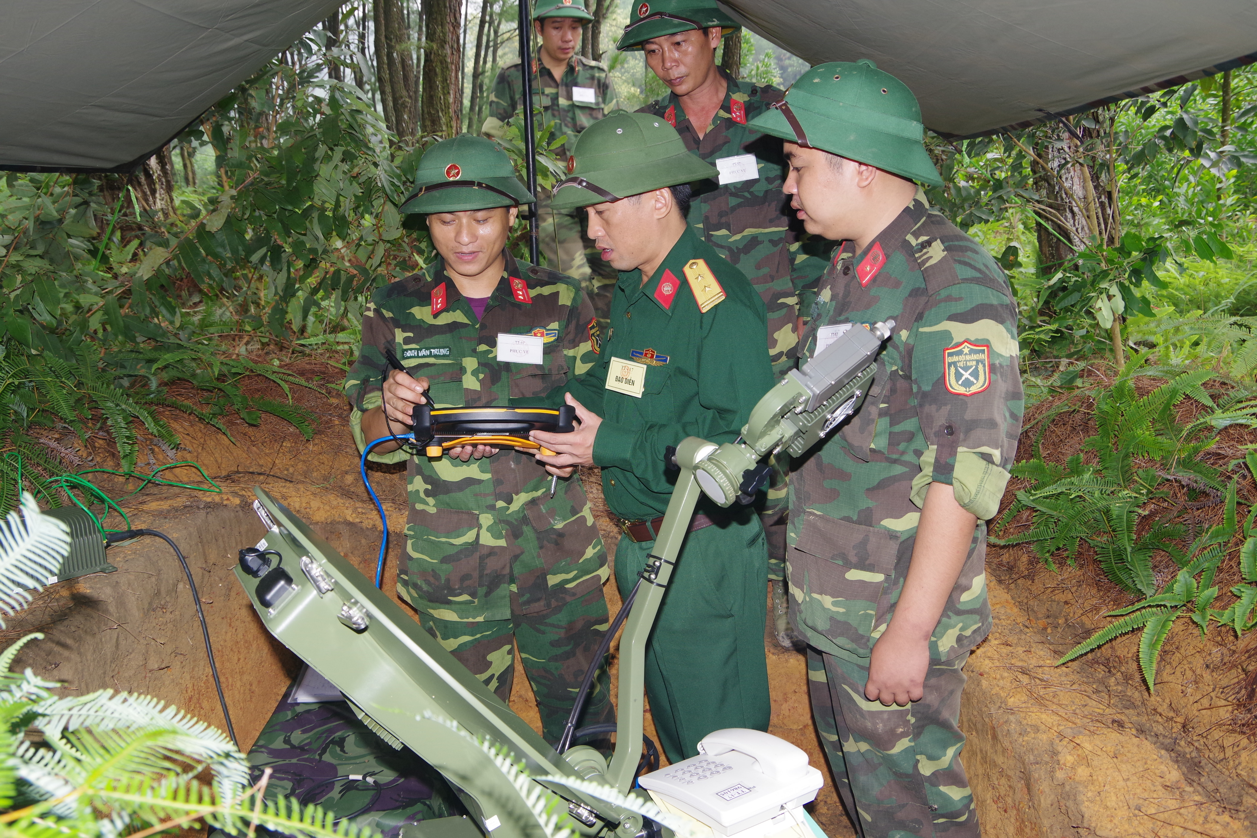Thượng úy Đinh Văn Trung (bên trái) luôn bảo đảm thông tin liên lạc thông suốt trong mọi nhiệm vụ.