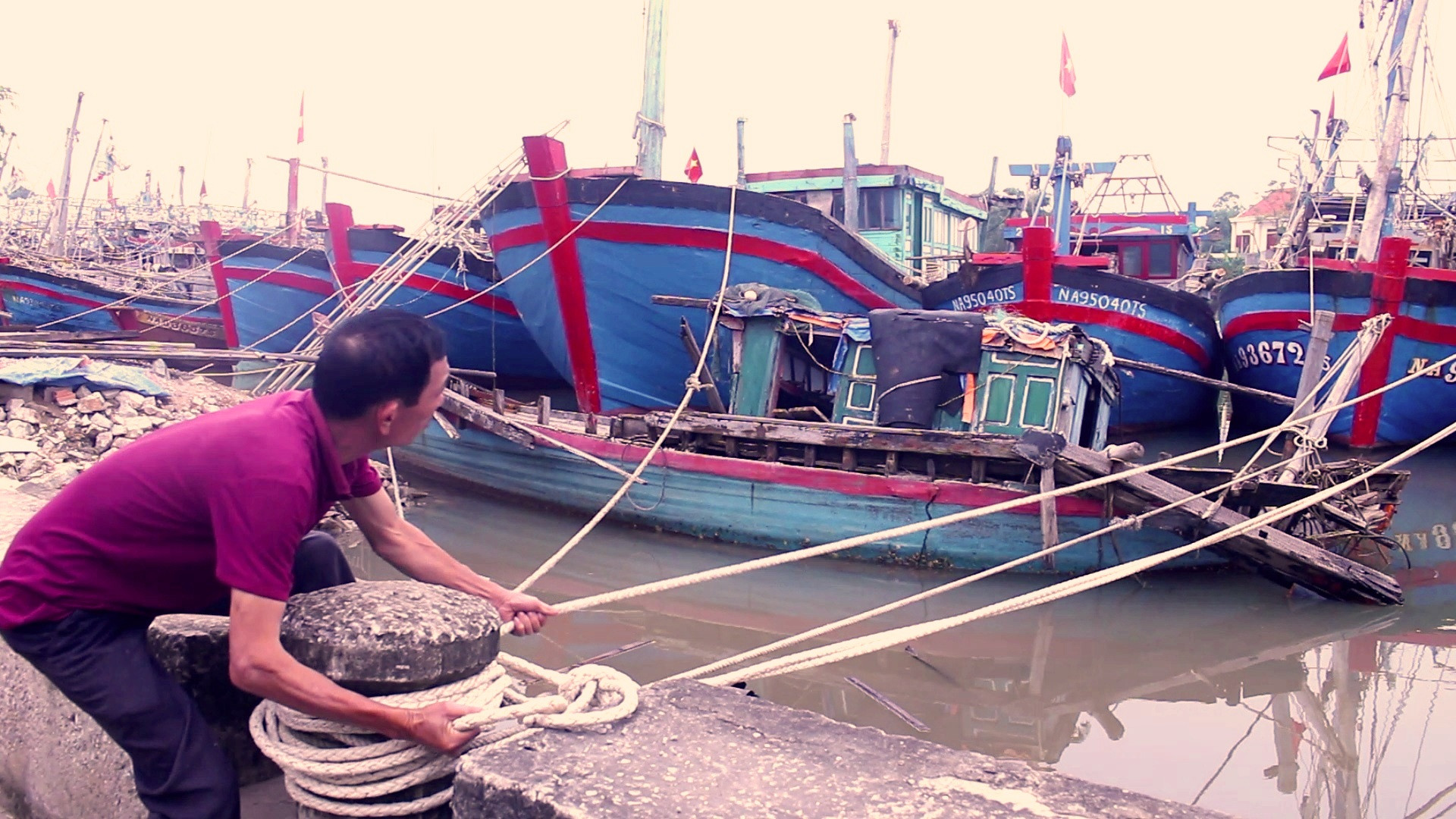 Bà con ngư dân thị xã Hoàng Mai chằng chống tàu thuyền khi về bờ neo đậu. Ảnh Việt Hùng