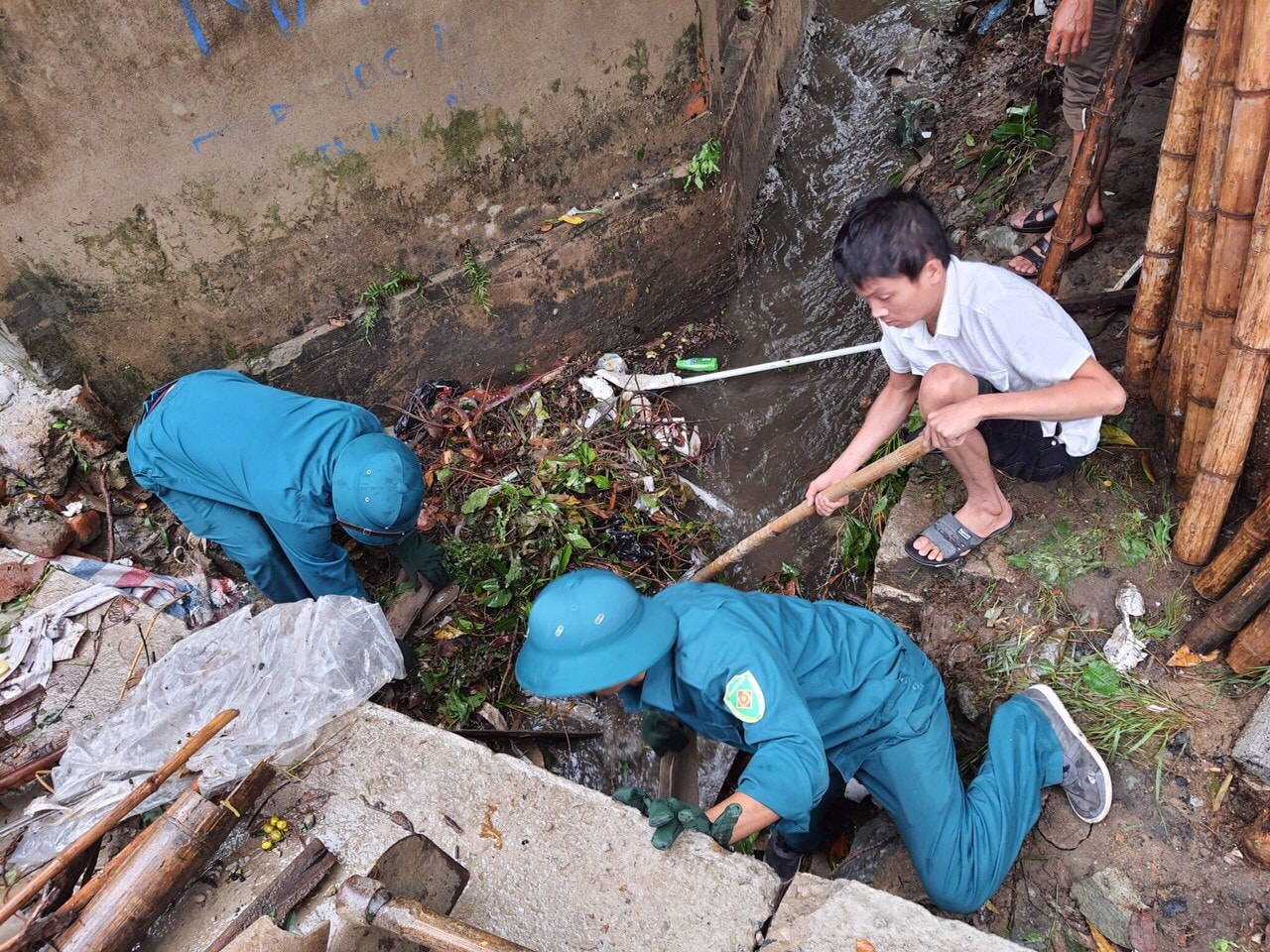 Phường Trường Thi (TP Vinh) huy động lực lượng dân quân và tự vệ dân phố nạo vét miệng cống rãnh dễ gây ách tắc dòng chảy trong chiều 28/10. Ảnh: P.V