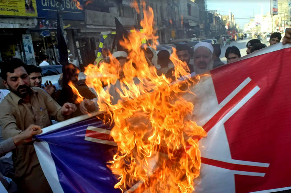 Các thương nhân Pakistan đốt  cờ Pháp trong cuộc biểu tình hôm thứ 26/10. Ảnh AP