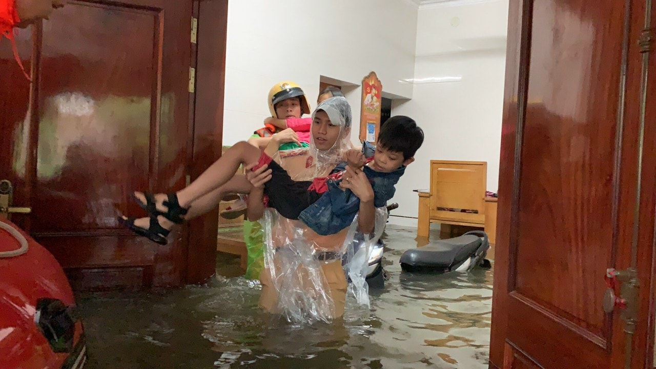 Cảnh sát giao thông Công an thành phố Vinh sơ tán người dân phường Bến Thủy bị ngập sâu trong lũ. Ảnh: Đức Vũ.