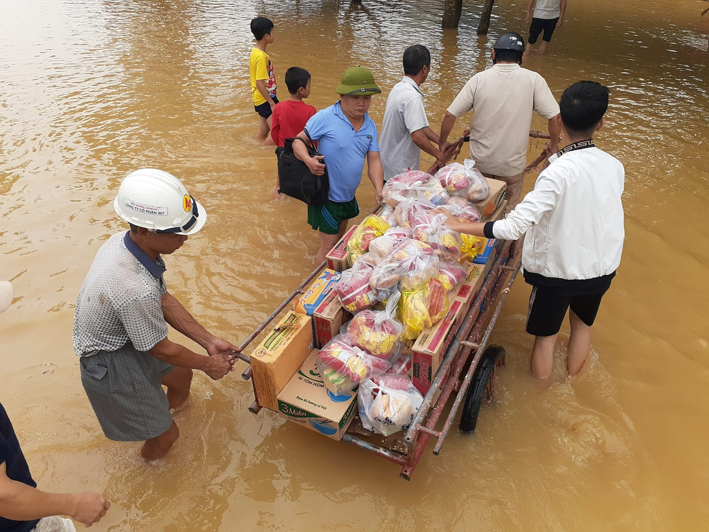 Người dân vùng lũ đi nhận quà cứu trợ. Ảnh: Huy Thư