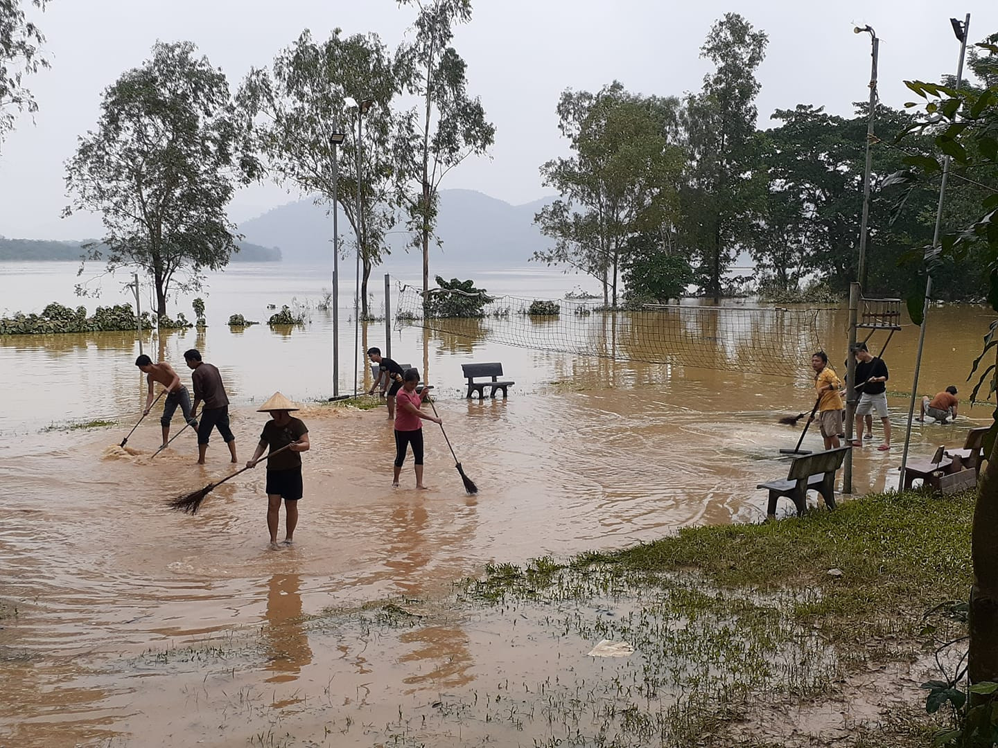 Người dân xã Thanh Giang vệ sinh sân thể thao khi nước lũ rút. Ảnh: Huy Thư