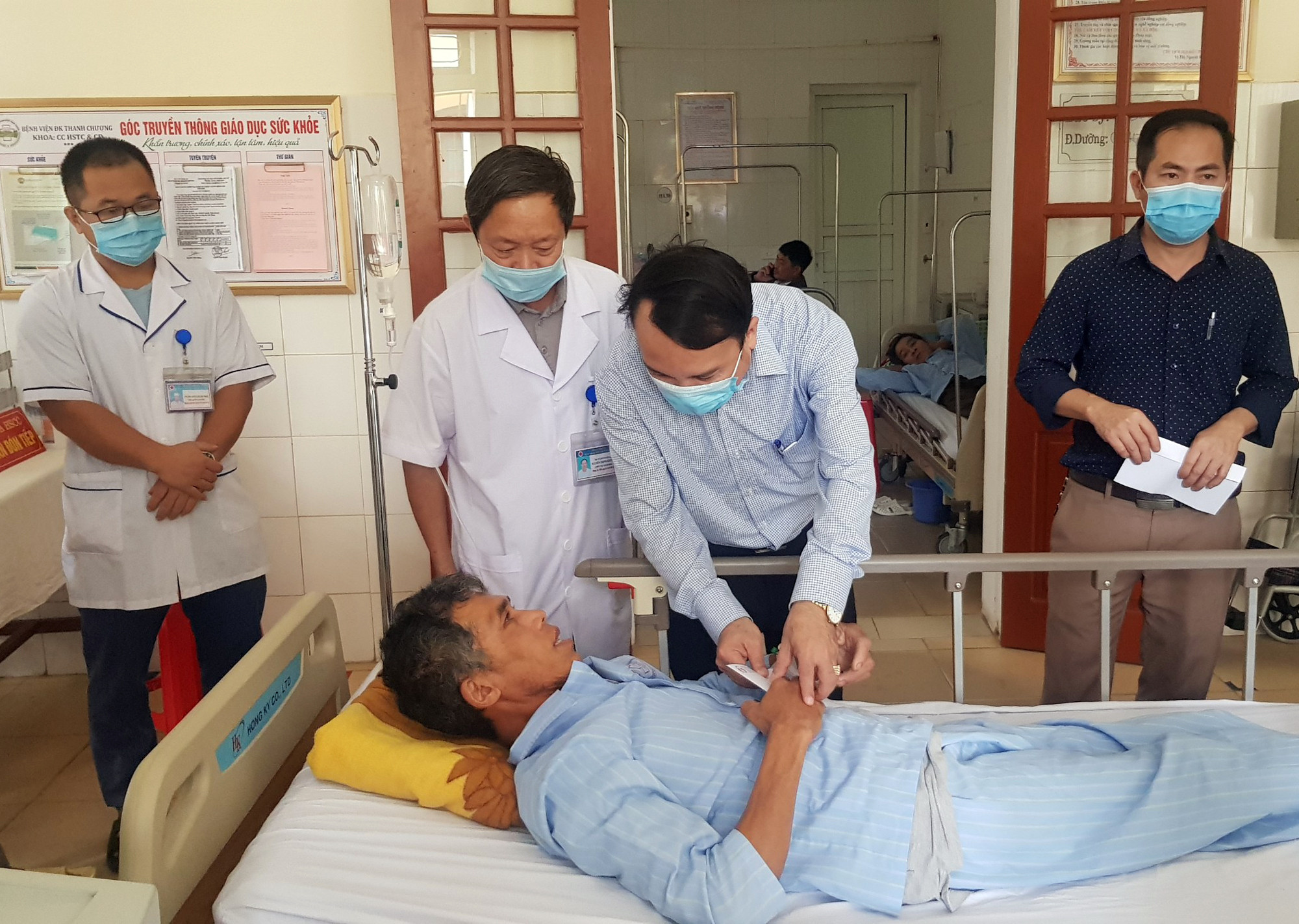 Lãnh đạo Sở Y tế tặng quà động viện bệnh nhân Trần Công Nam. Ảnh: Thành Chung