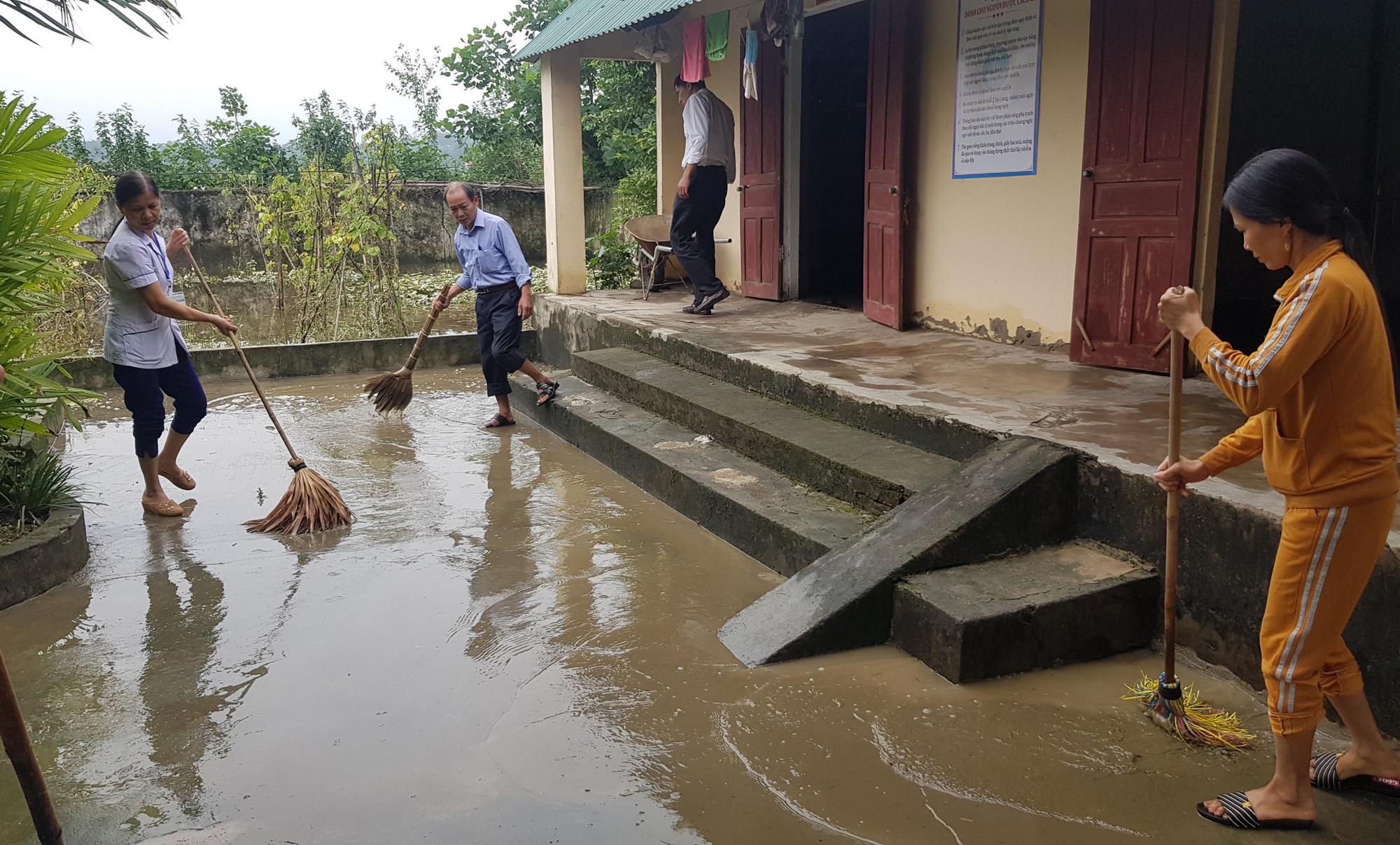 Cán bộ trạm y tế xã Thanh Chi vệ sinh môi trường sau mưa lũ. Ảnh: Thành Chung