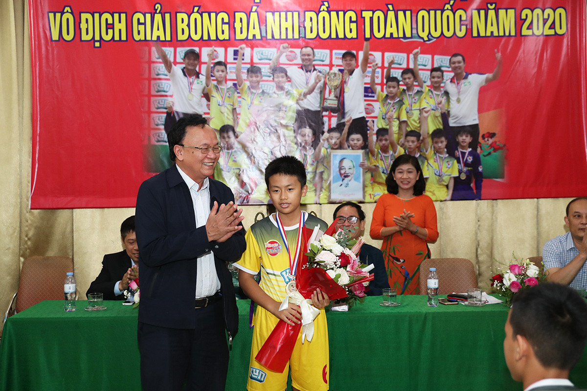 Không chỉ đá bóng hay, trong đội U11 SLNA còn có một cầu thủ đặc biệt. Ông Nguyễn Hồng Thanh - TGĐ, chủ tịch CLB bóng đá SLNA tặng hoa cho em Nguyễn Thái Nam Kiệt là học sinh giỏi cấp tỉnh. Ảnh: Đức Anh 