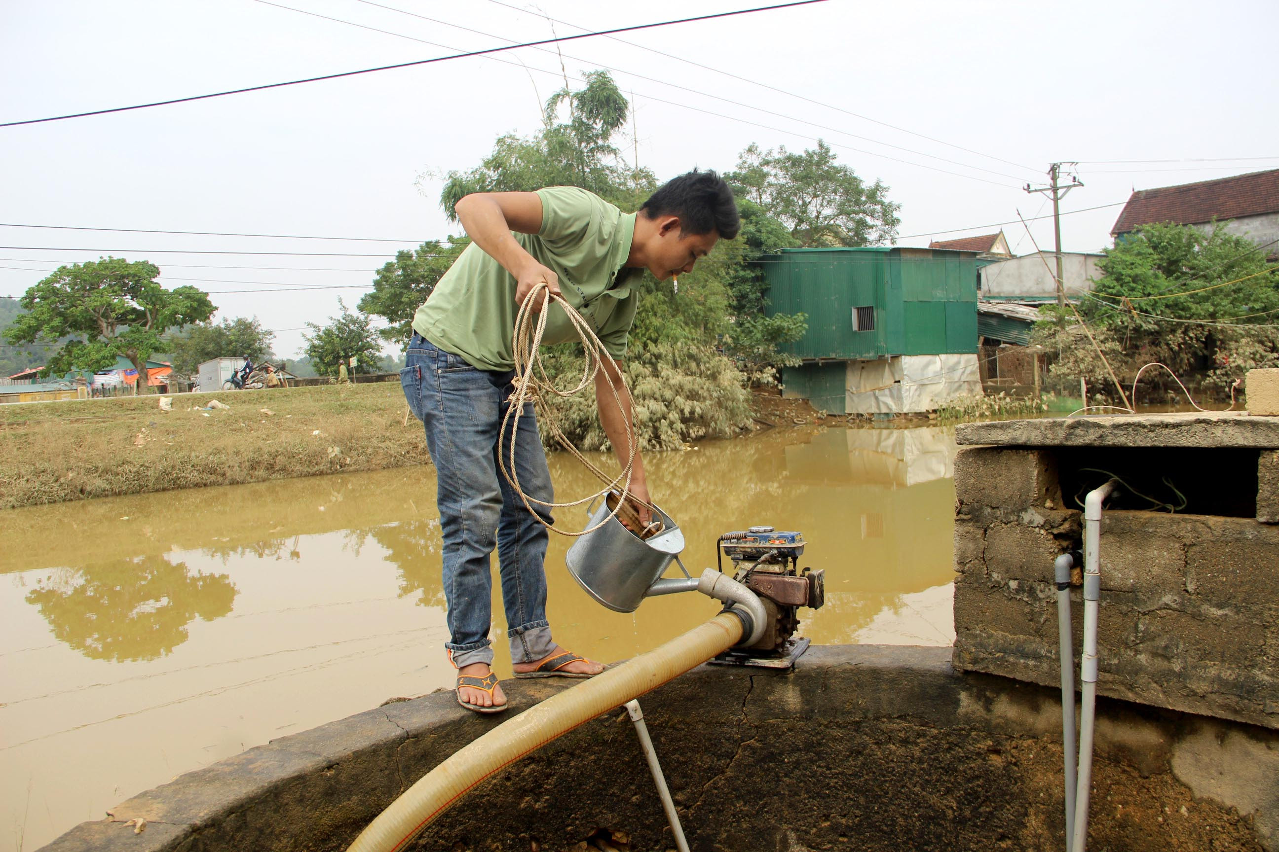 Anh hồ sỹ Văn cả tuần nay giúp các hộ dân trong xóm sử lý giếng nước vẫn không xuể. Ảnh: Quang An