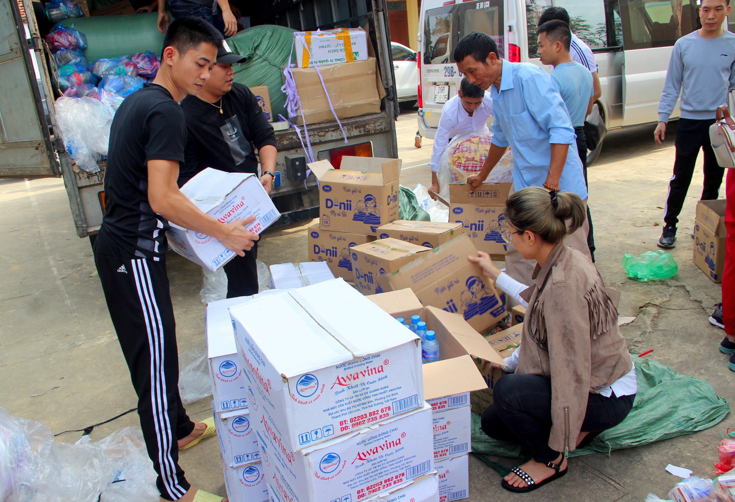 Các đoàn cứu trợ tăng cường cung cấp nước uống đóng chai cho bà con vùng lũ Thanh Chương. Ảnh: Quang An