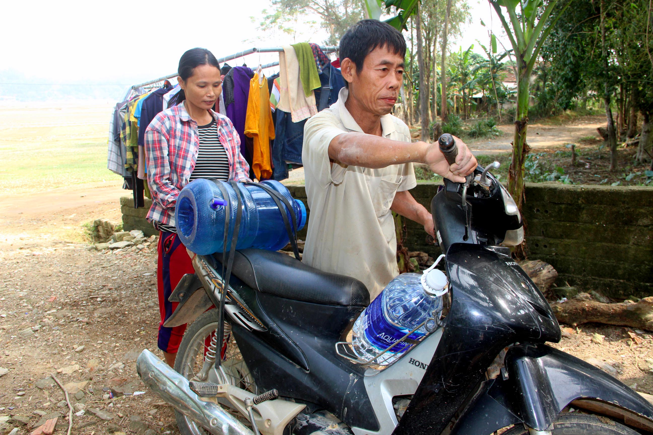 Gia đình ông Đinh Văn Sáng ở xóm Xuân Lan xã Thanh Xuân phải đi xin từng bình nước về sinh hoạt, vì giếng đào vị ô nhiễm. Ảnh: Xuân Hoàng