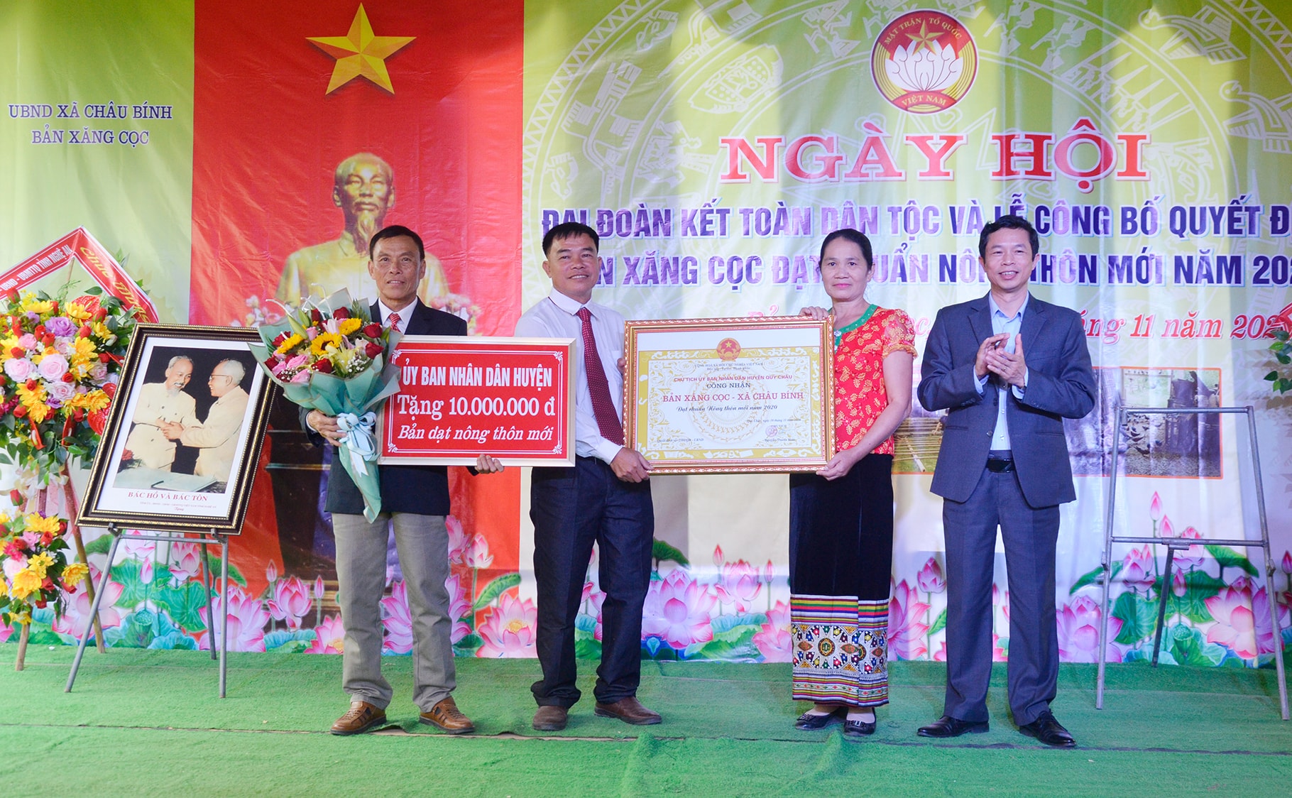 Lãnh đạo huyện Quỳ Châu trao bằng bản đạt chuẩn Nông thôn mới cho bản Xăng Cọc. Ảnh: Thanh Lê