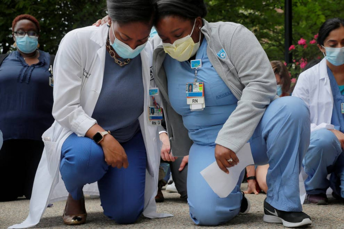 Hai nữ y tá Sasha Dubois và Farah Fevrin quỳ gối trong 8 phút 46 giây - khoảng thời gian một cảnh sát ghì đầu gối vào cổ George Floyd. Ảnh: Reuters