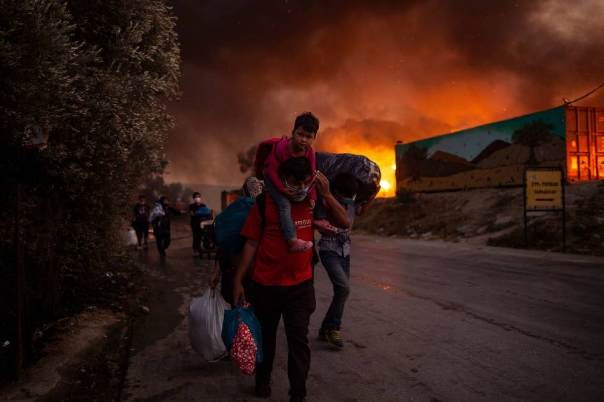 Những người di cư chạy trốn khỏi đám cháy tại trại tị nạn Moria trên đảo Lesbos, Hy Lạp ngày 9/9. Vụ hỏa hoạn đã thiêu rụi trại tị nạn lớn nhất châu Âu, khiến khoảng 12.000 người không có nơi trú ẩn. Ảnh: Getty Images