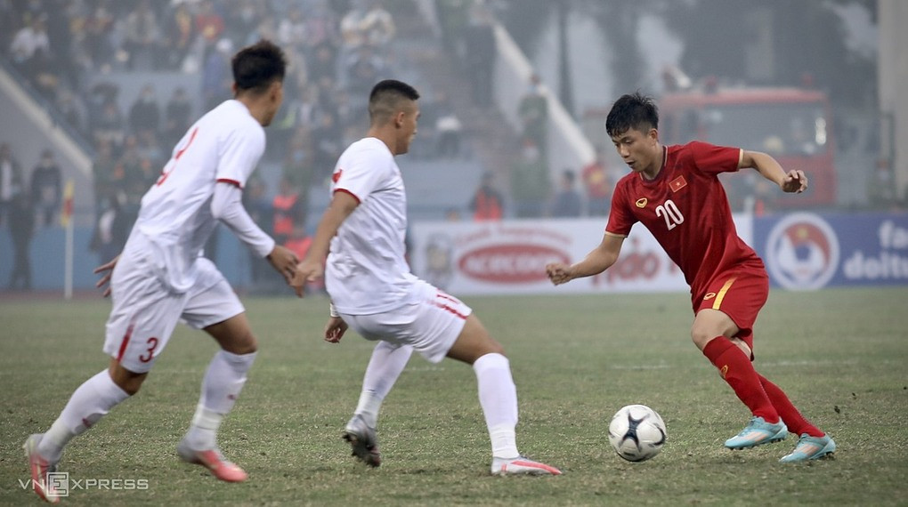 Phan Văn Đức (đỏ) đi bóng trước sự bủa vây của các cầu thủ U22 Việt Nam, trong trận giao hữu trên sân Việt Trì (Phú Thọ) hôm 27/1. Ảnh: Kim Hòa.