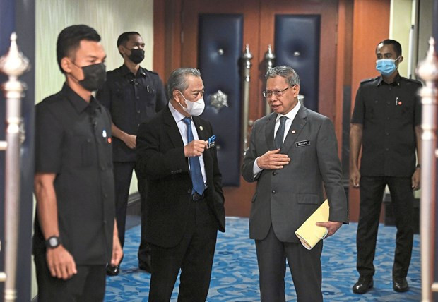Thủ tướng Malaysia Muhyiddin Yassin (trái) trao đổi với Bộ trưởng Mustapa Mohamed bên ngoài tòa nhà Quốc hội. Ảnh: Bernama