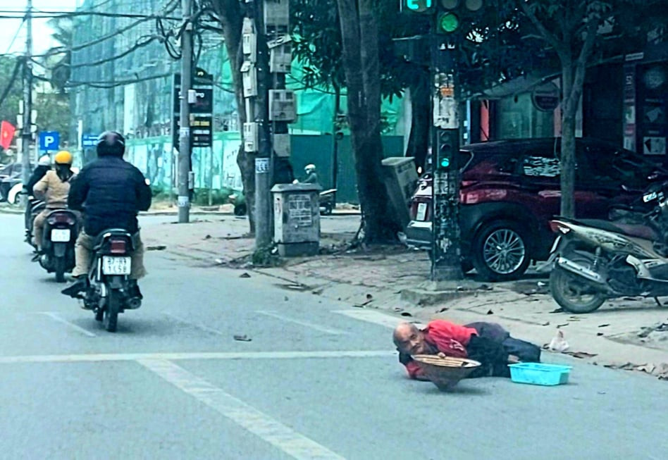 Một người ăn xin cao tuổi lê lết ra lòng đường để xin tiền người đi đường (ảnh chụp tại khu vực đèn tín hiệu xanh đỏ, điểm giao đường Lê Hồng Phong và đường Nguyễn Đức Cảnh ngày 7/1/2021). Ảnh: Nhật Lân
