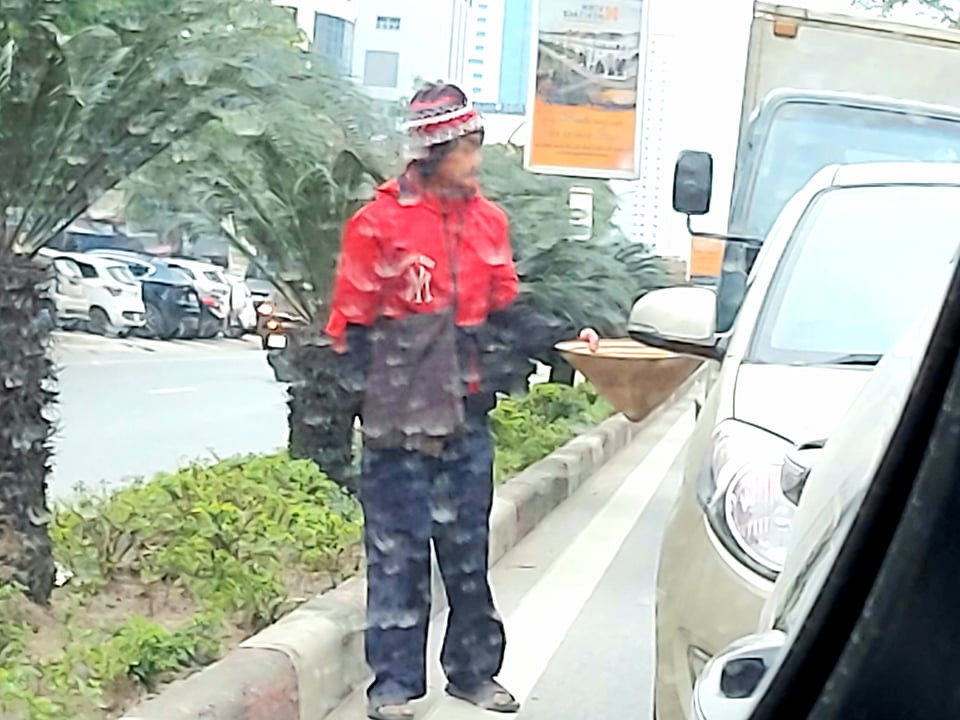 Cũng người ăn xin từng nằm lê lết trên đường Lê Hồng Phong, đã đi lại bình thường xin tiền người tham gia giao thông trên đường Quang Trung trong ngày 11/1/2021. Ảnh: Nhật Lân