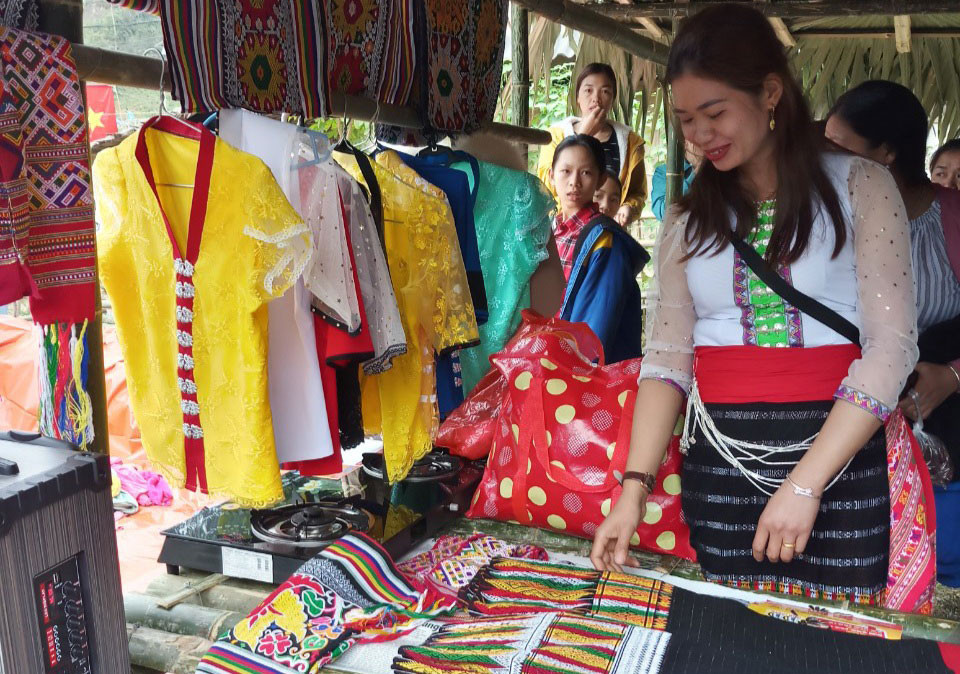 Nhiều phụ nữ tranh thủ hội chợ sắm cho mình những chiếc váy áo dệt bằng thổ cẩm để trưng diện ngày Tết. Ảnh: Đào Thọ