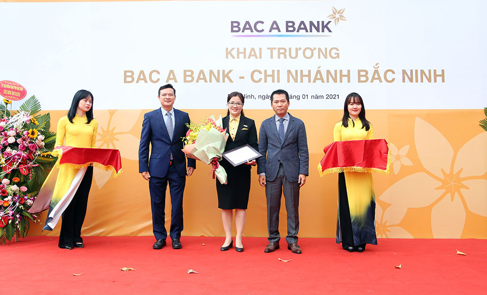 Ông Đặng Trung Dũng - Phó TGĐ Thường trực Ngân hàng TMCP Bắc Á trao quyết định và tặng hoa cho BAC A BANK Chi nhánh Bắc Ninh. Ảnh: P.V