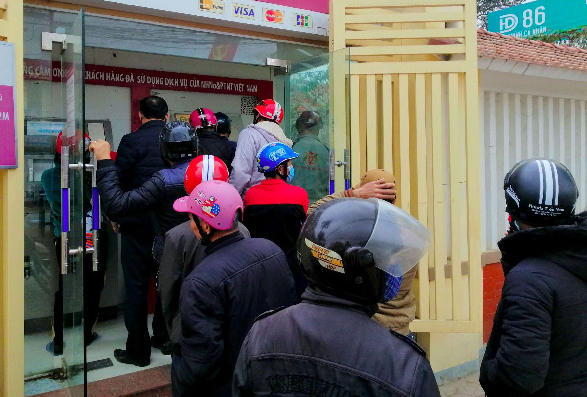 Hàng người xếp dài tại cây ATM trên địa bàn thị trấn Đô Lương trong chiều 1/2. Ảnh: Nguyên Châu