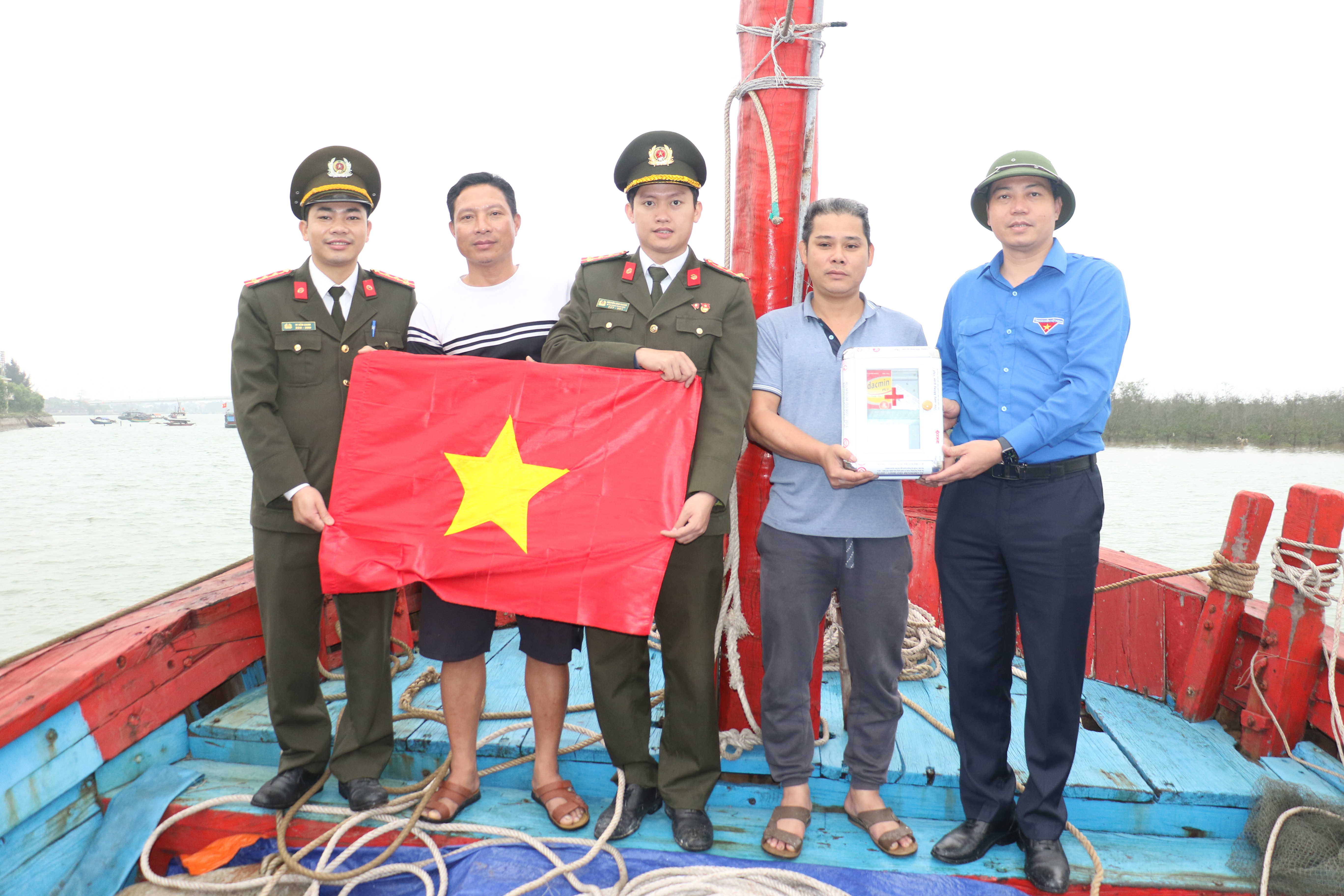 Trao cờ Tổ quốc cho ngư dân Giáo xứ Trang Cảnh, xã Nghi Xuân, huyện Nghi Lộc. Ảnh: 