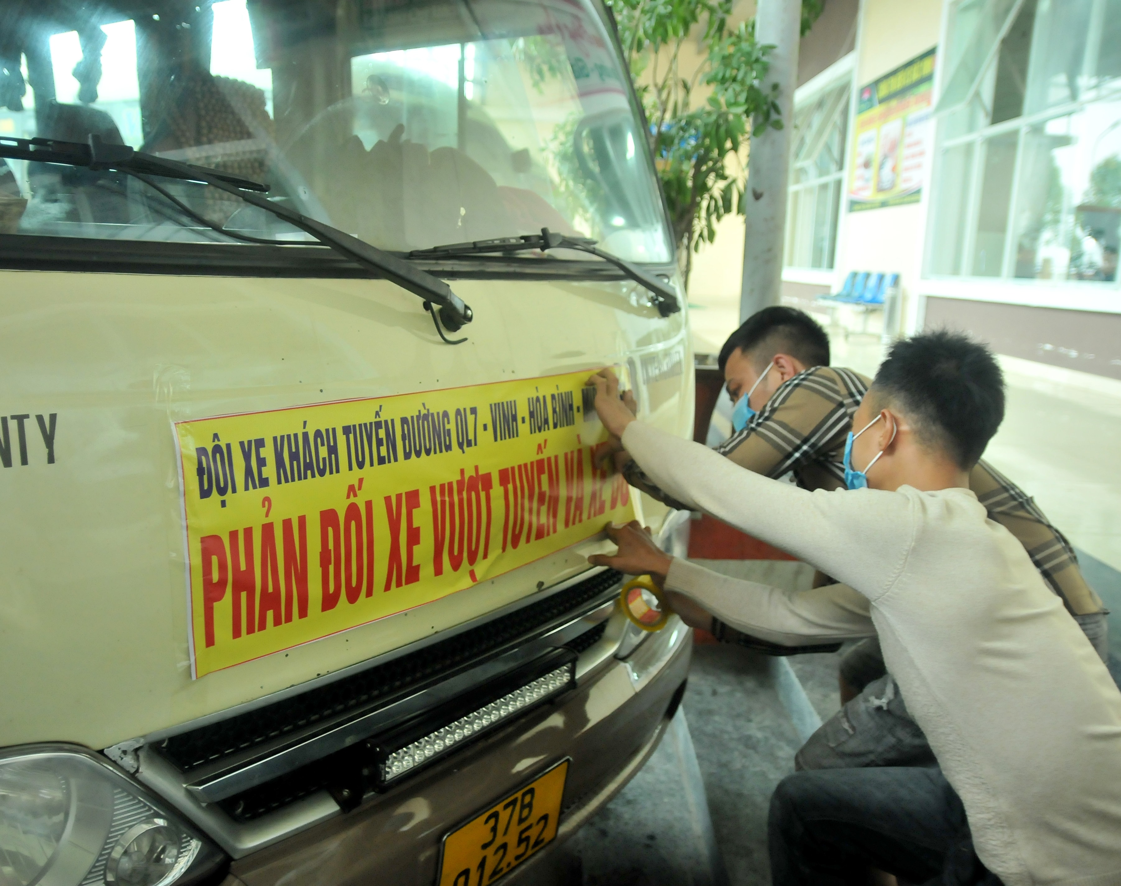 Các lái xe dán băng rôn phản đối xe dù, xe vượt tuyến chèn ép bắt khách trái quy định. Ảnh: Tiến Đông