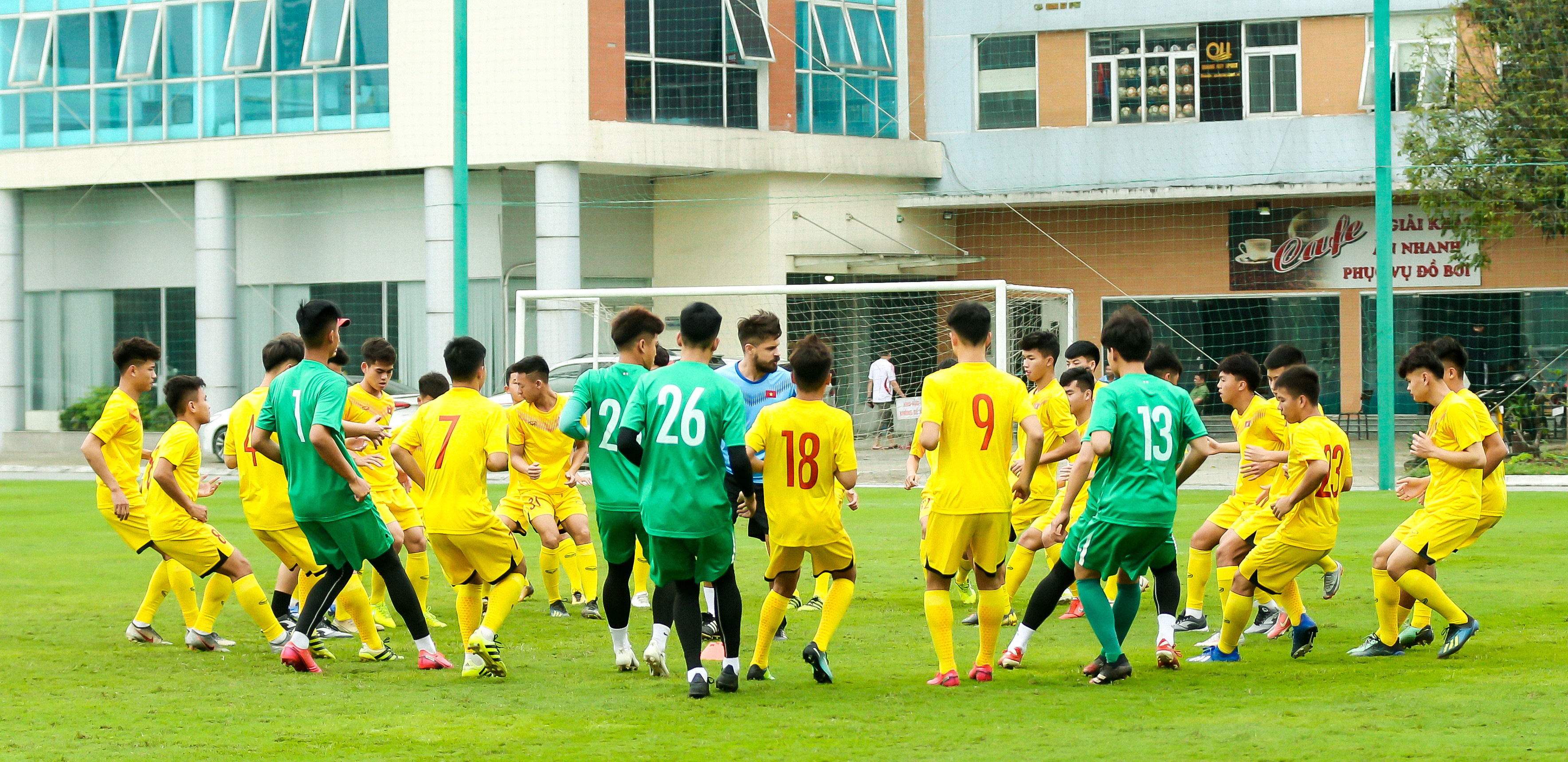 Các cầu thủ U18 Việt Nam khởi động cùng HLV thể lực người nước ngoài trước khi bước vào buổi tập. Ảnh: Hải Hoàng