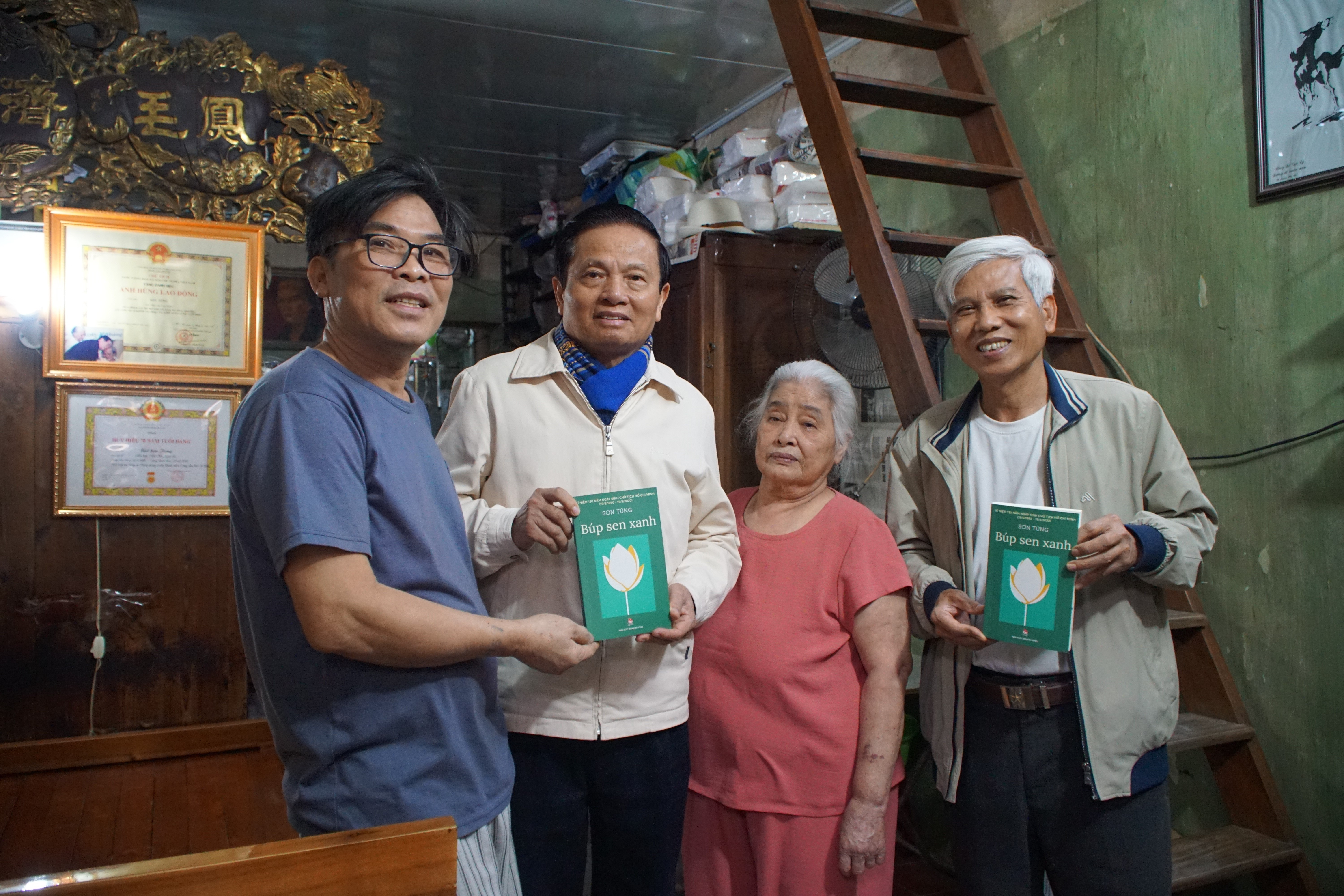 Vợ nhà văn Sơn Tùng thay mặt nhà văn tặng sách. Ảnh: Nguyễn Công Kháng