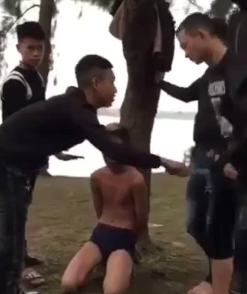 Nam thanh niên bị bắt quỳ để nhóm người nhục mạ. Ảnh cắt từ clip