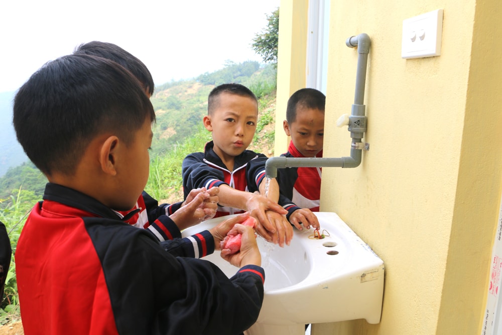 Học sinh rửa tay tại nhà vệ sinh mới được bàn giao sau giờ học. Ảnh: N.H