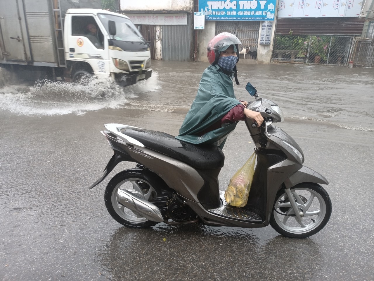 Sau khi đi qua đoạn đường bị ngập, xe máy của người phụ nữ này đã bị chết máy phải chờ người nhà ra đẩy về. Ảnh: Tiến Đông