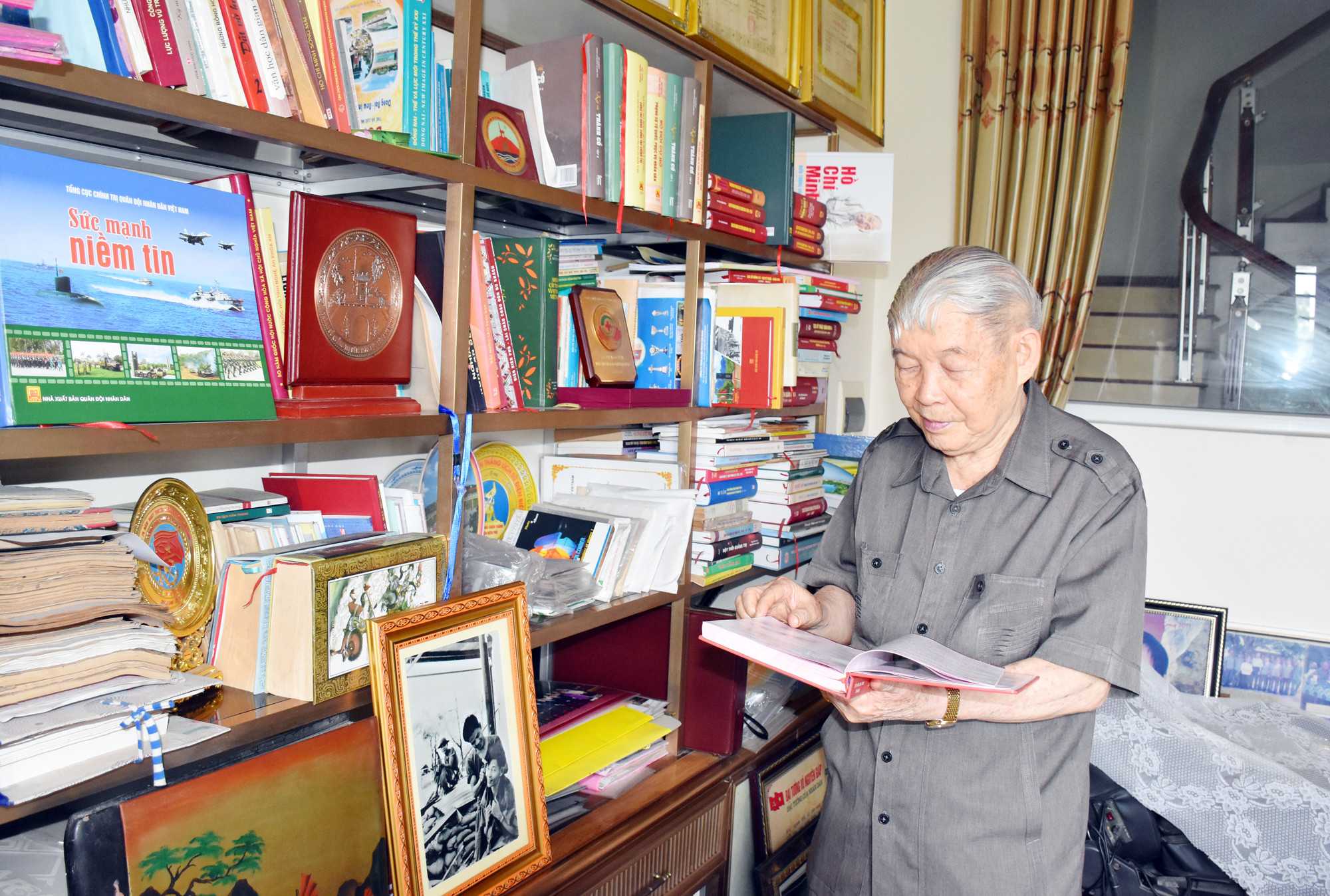 Thiếu tướng Cao Xuân Khuông bên tủ sách tư liệu về cuộc chiến tranh chống Mỹ, cứu nước. Ảnh: Công Kiên