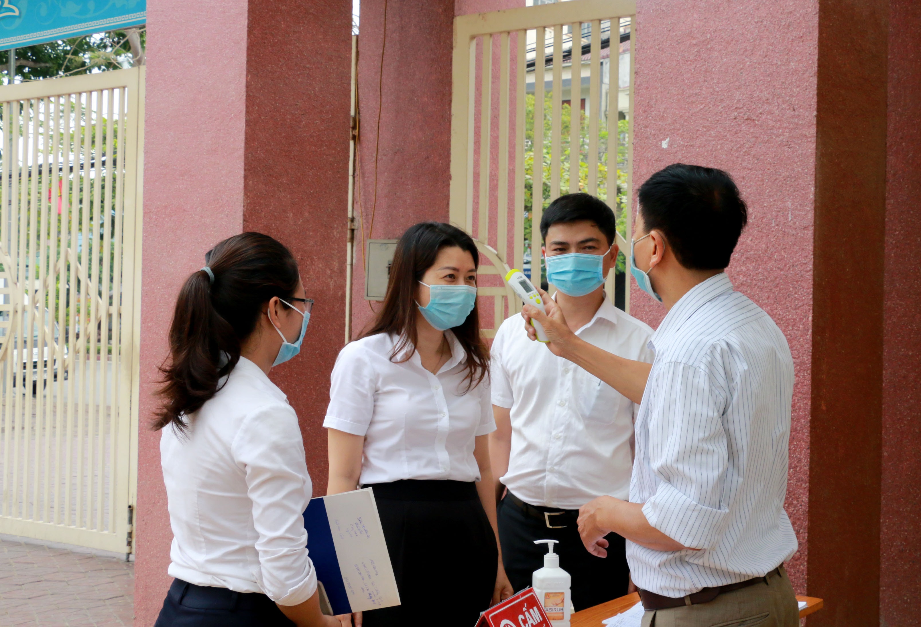 Các trường học thực hiện nghiêm túc việc khai báo y tế và đo thân nhiệt với khácch vào làm việc. Ảnh: MH.